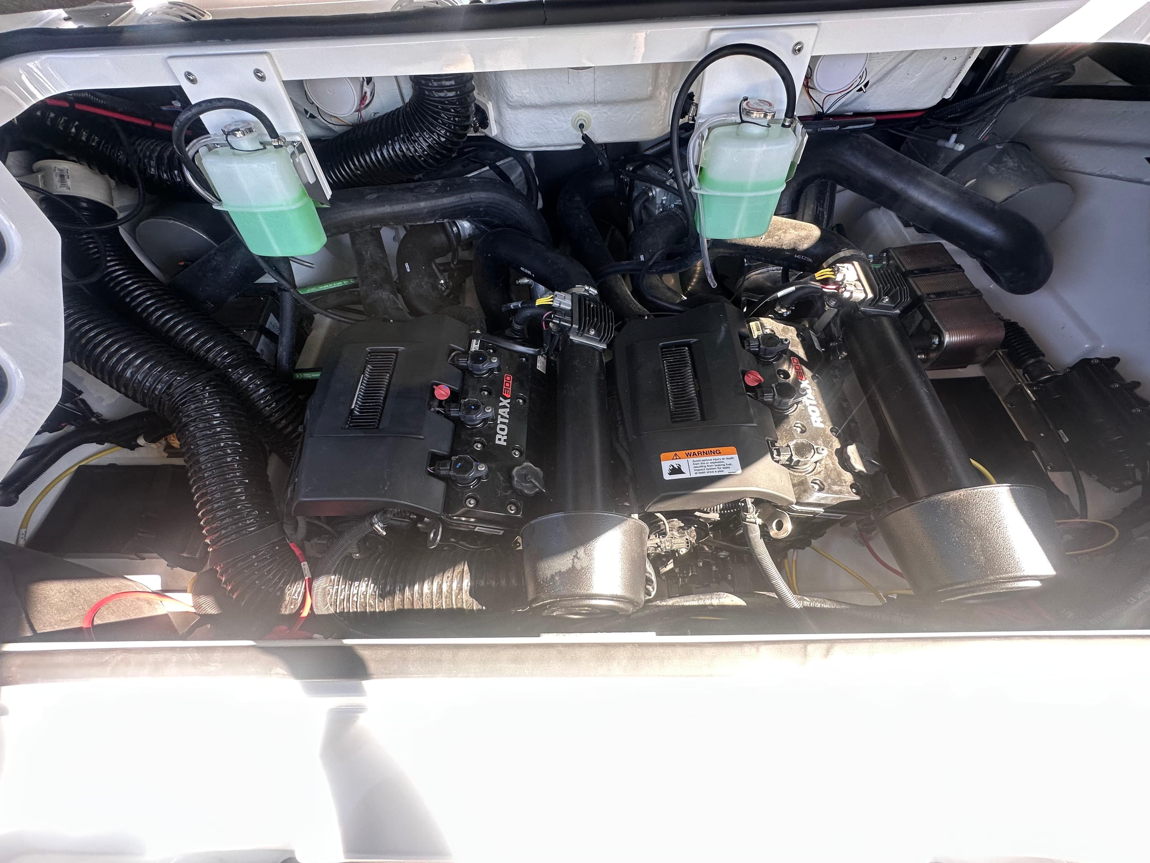 Engine compartment of a 2025 Scarab 235 LX boat, showcasing dual motors and components.