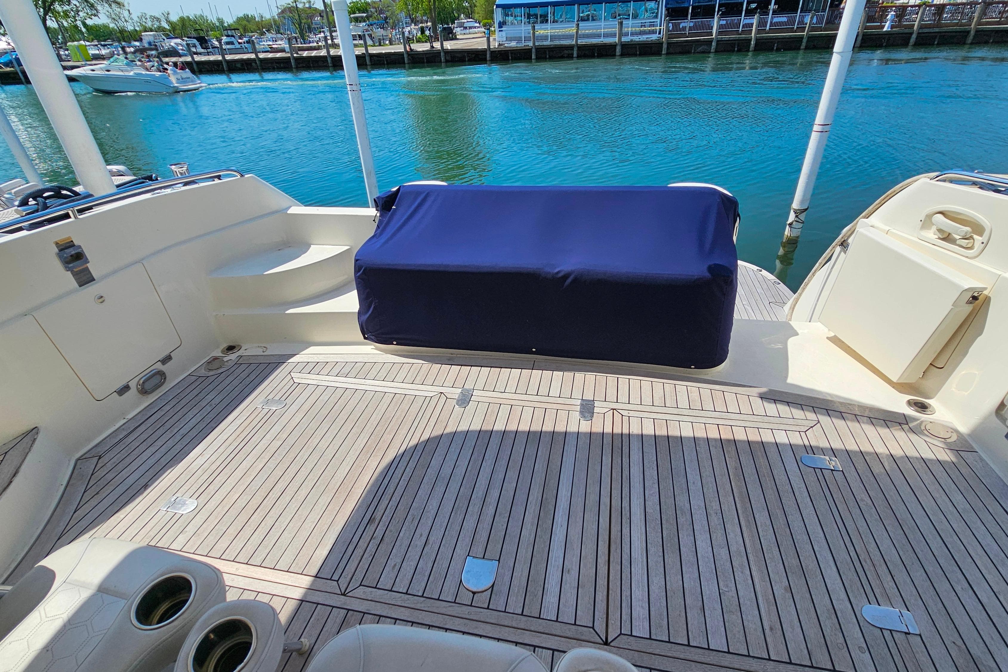 Sunseeker Manhattan 62 yacht deck, 1998 model, with covered seating and waterfront view.