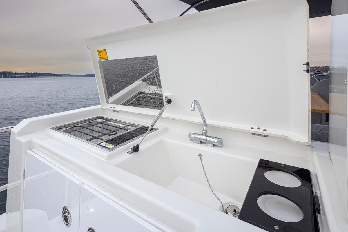 Outdoor kitchen on 2026 Beneteau Swift Trawler 41 Fly, featuring sink and stove.