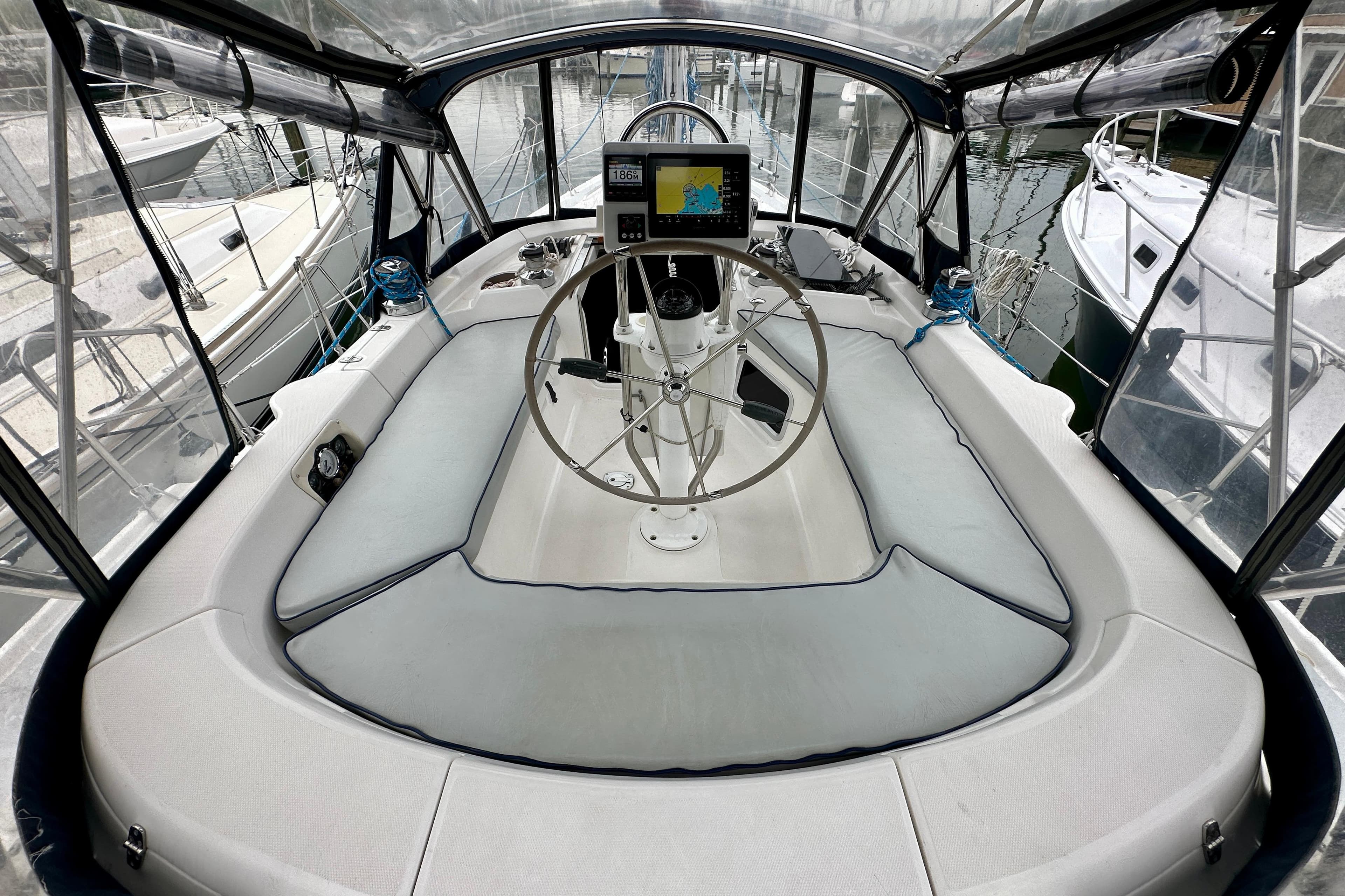 Cockpit of 2002 Hunter Passage 420 sailboat with steering wheel and navigation system.