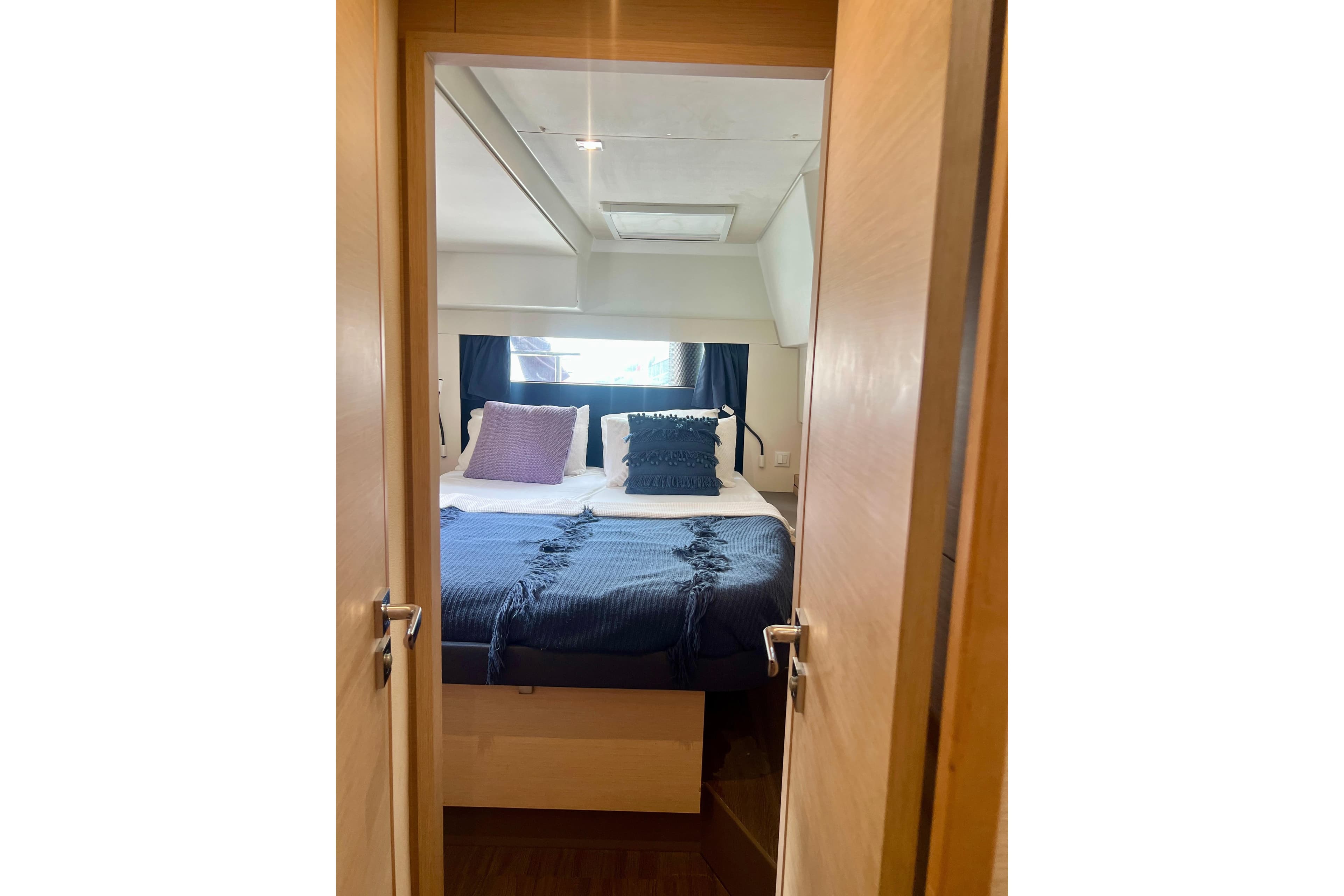 Cozy bedroom interior of 2018 Fountaine Pajot Saona 47 yacht with stylish bedding.