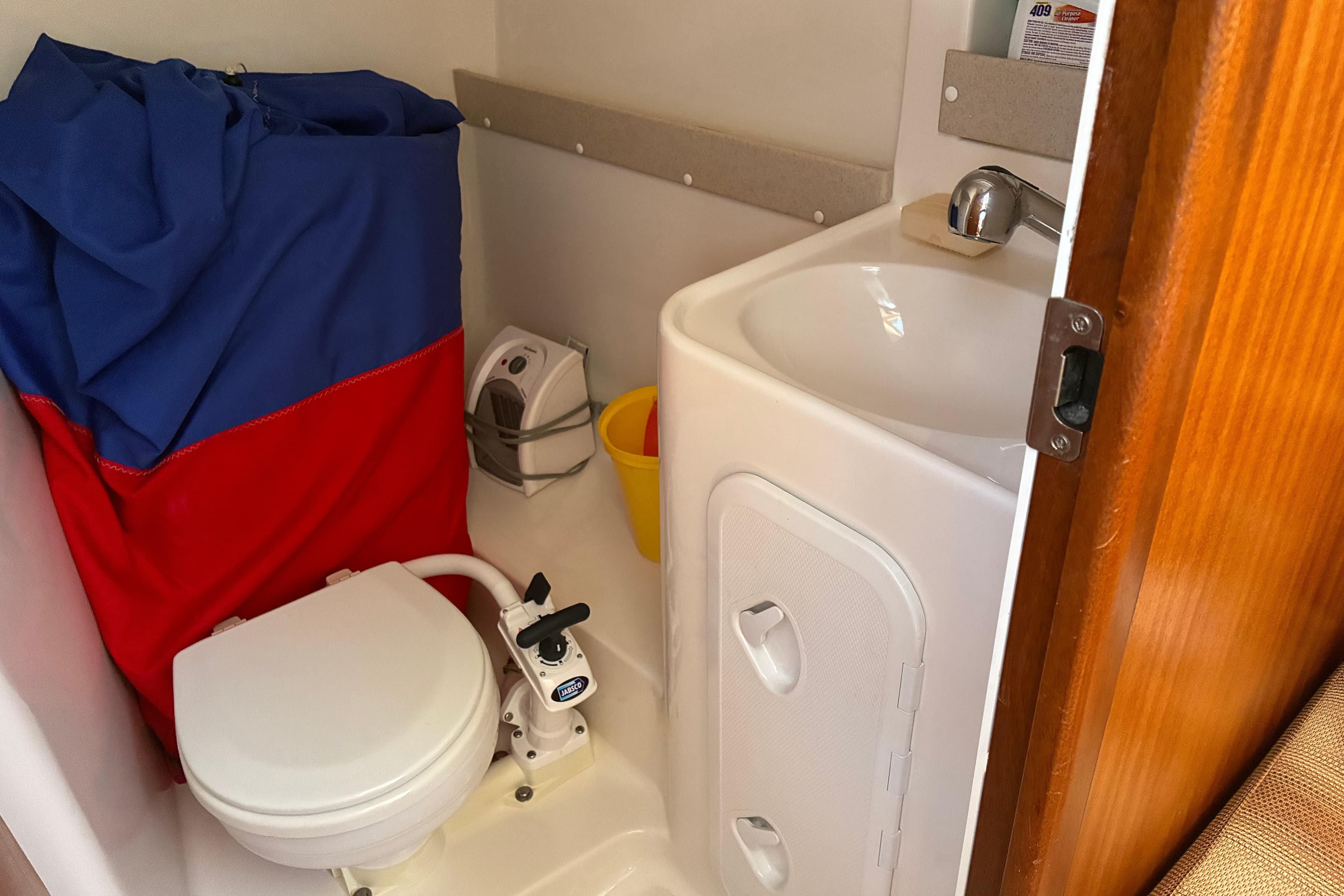 Compact bathroom in a 2007 Delphia 33 yacht with toilet, sink, and storage.