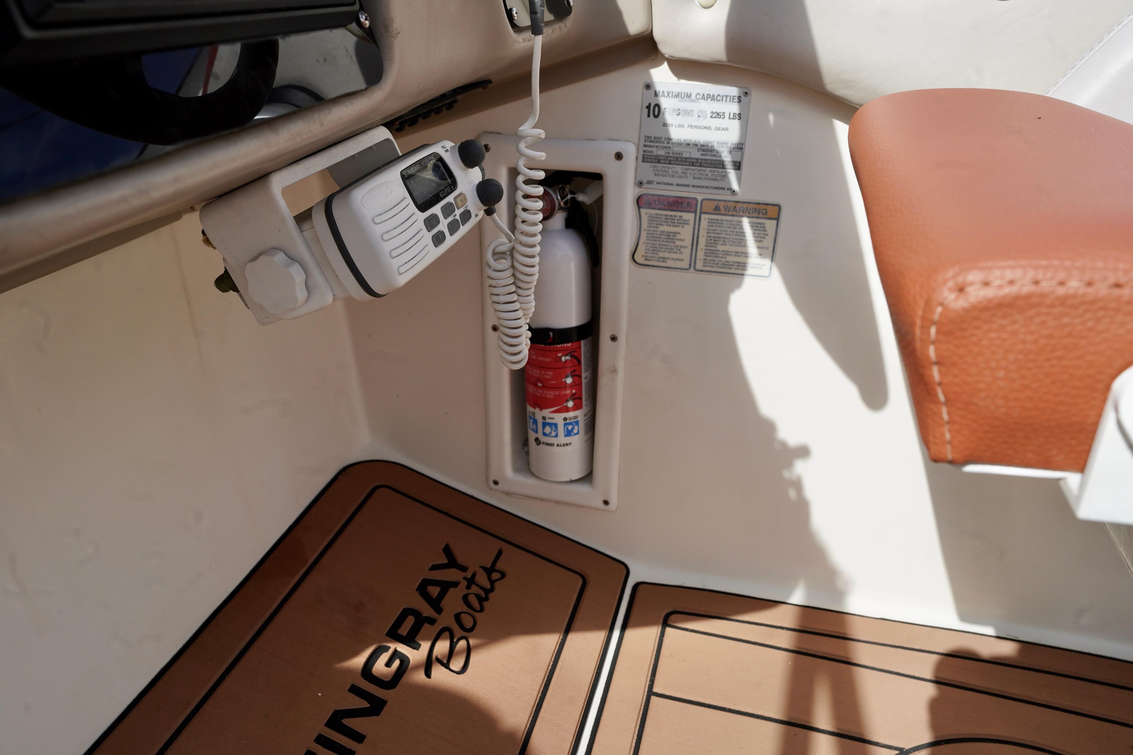 Interior of a 2001 Stingray 240 LS boat with fire extinguisher and radio.