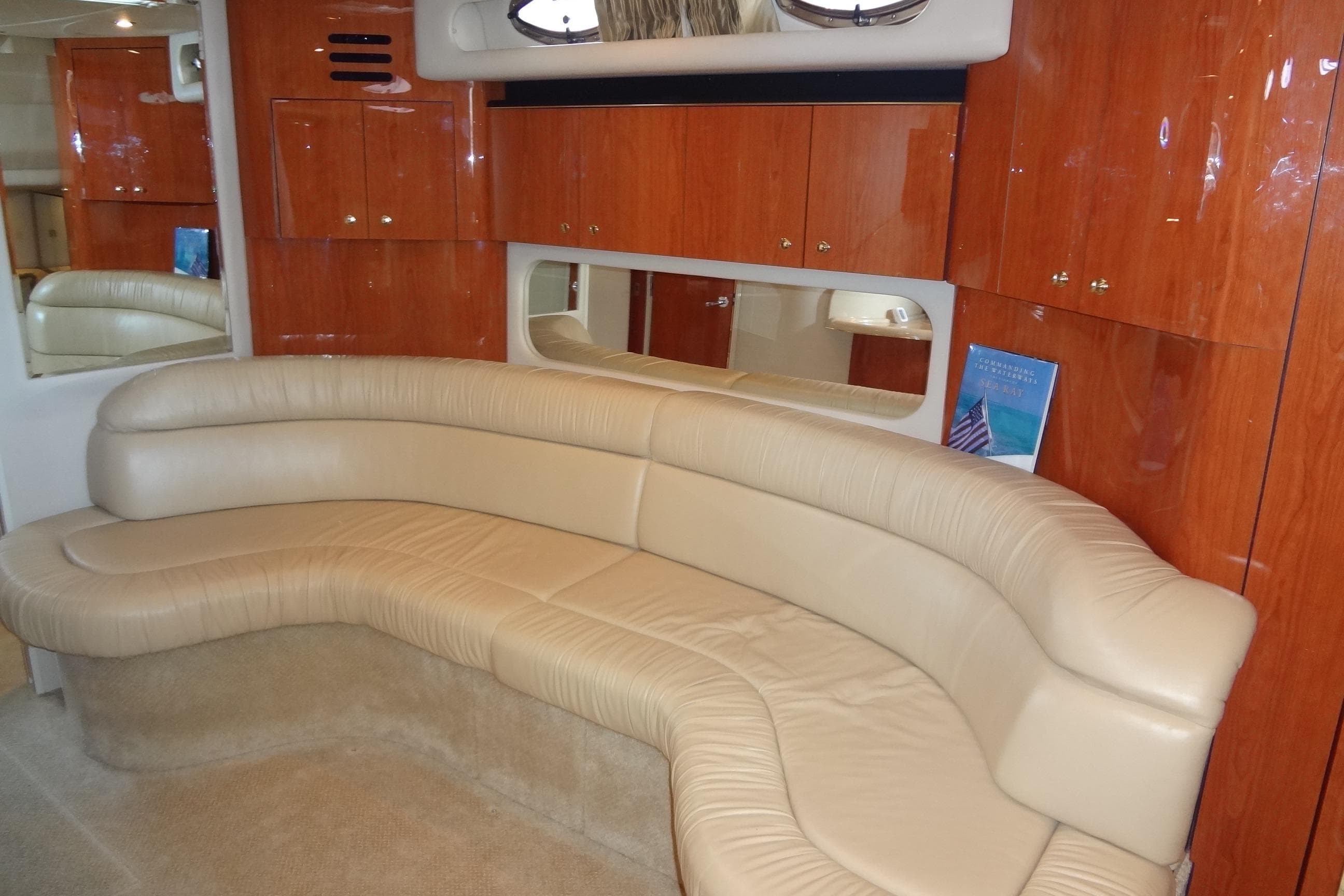 Luxurious interior of 2001 Sea Ray 380 Sundancer with beige leather seating and wooden cabinets.