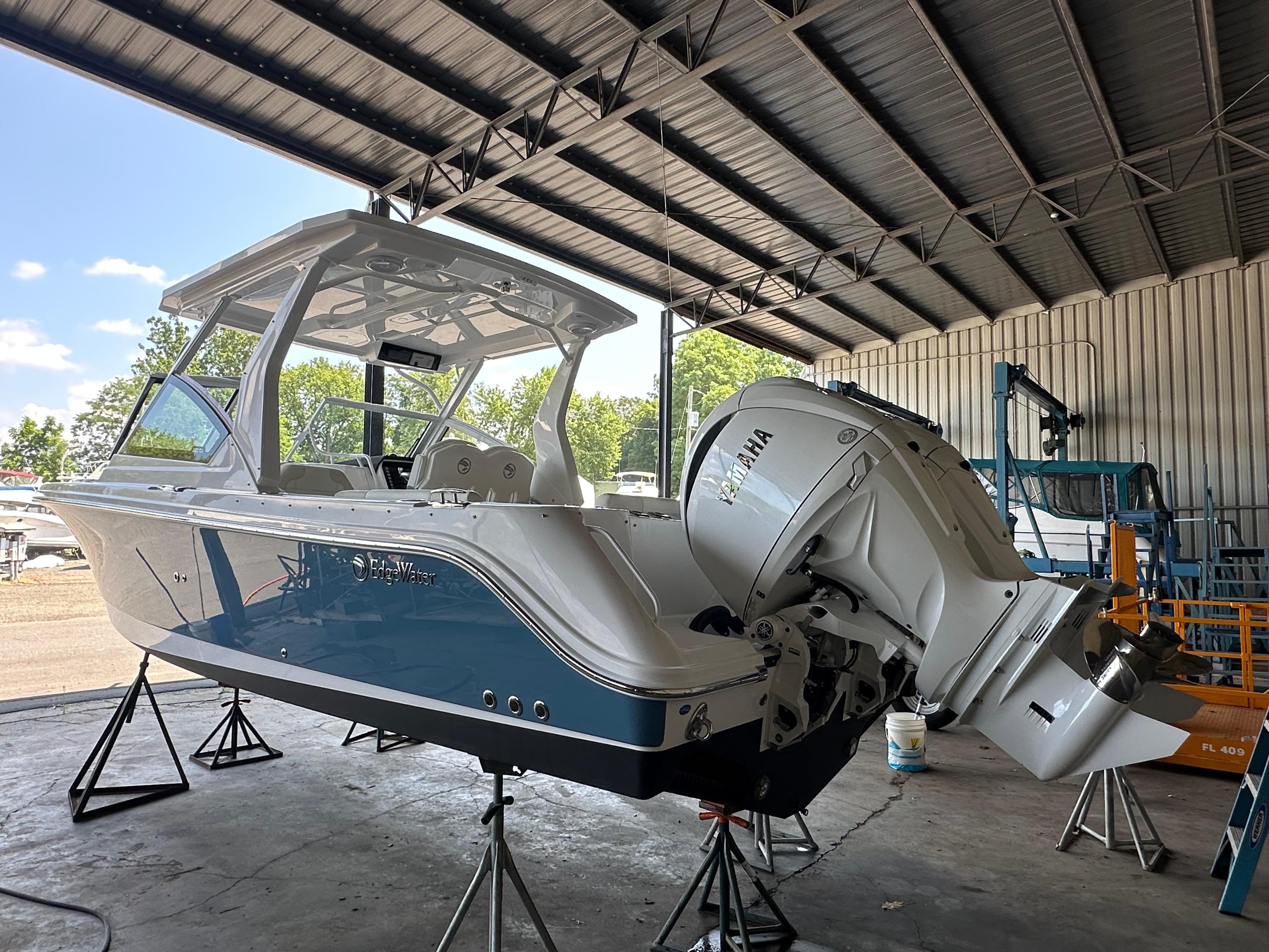 2026 Edgewater 262CX Crossover boat in a covered marina, featuring a Yamaha outboard motor.