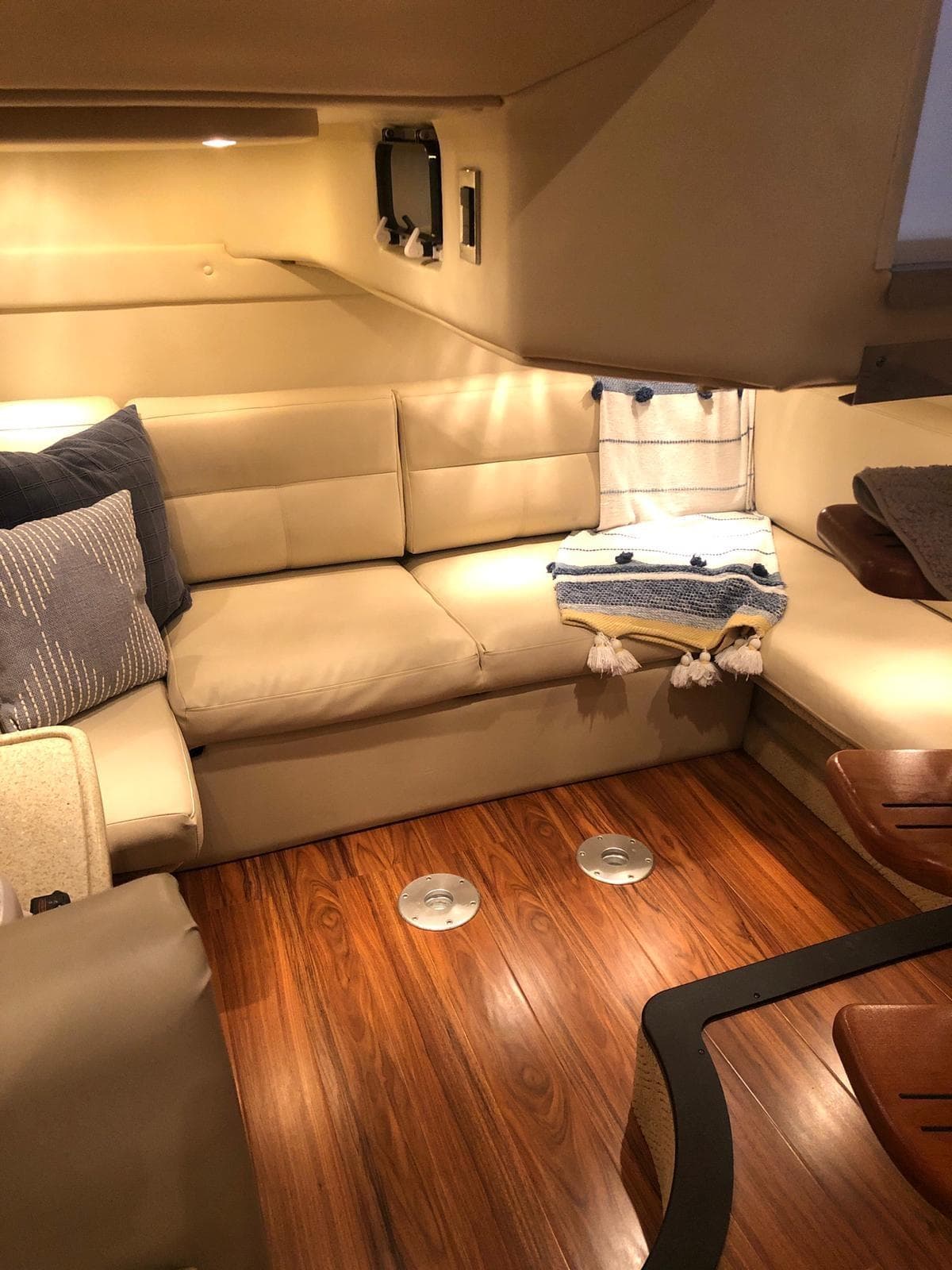 Interior of a 2008 Rinker 350 Express Cruiser with beige seating and wooden flooring.