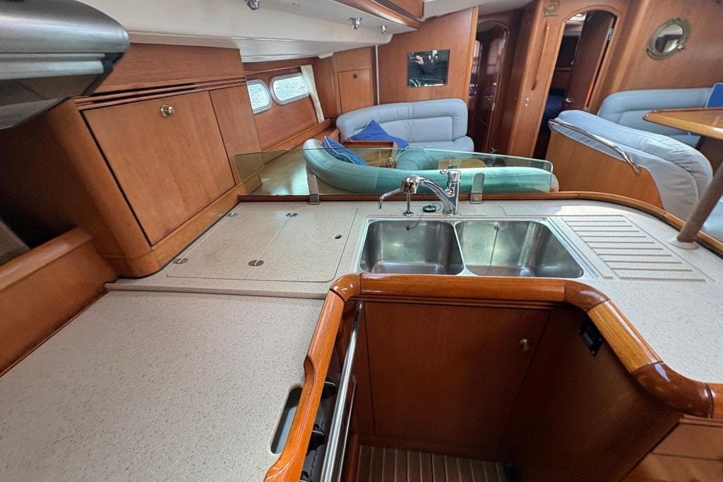 Luxurious interior of 2005 Jeanneau Sun Odyssey 54 DS yacht with modern kitchen amenities.