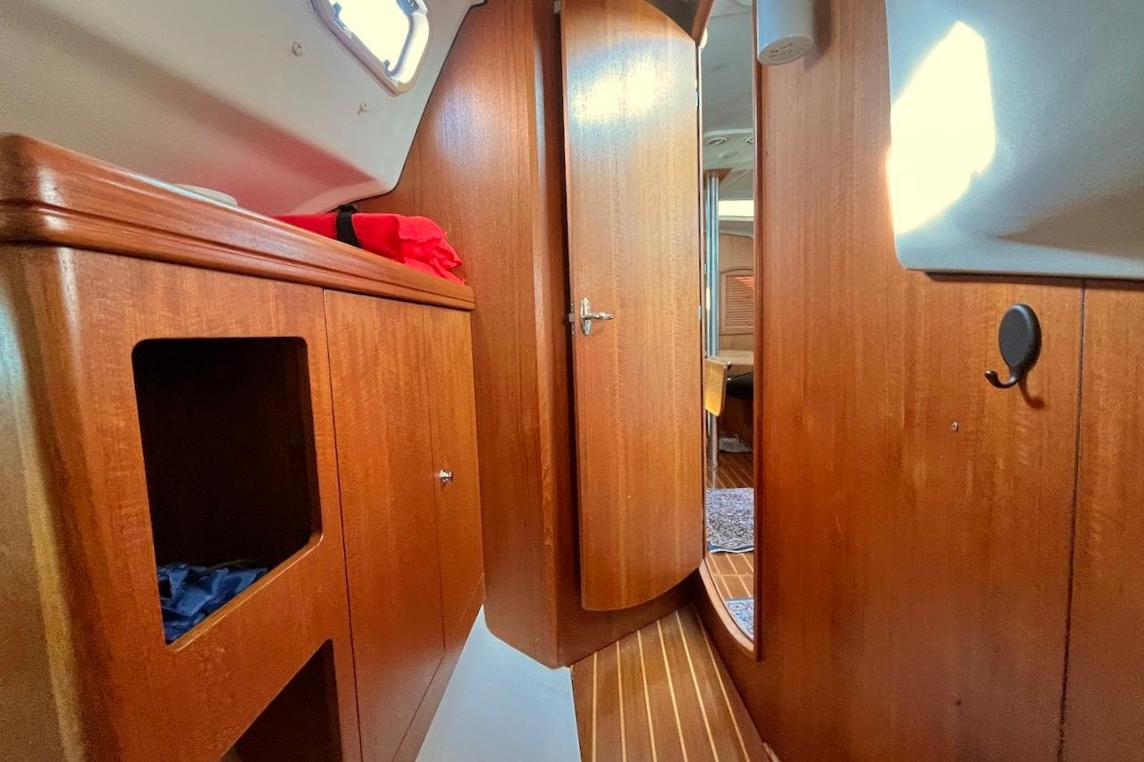 Interior of a 2002 Hunter 326 sailboat with wooden cabinetry and door.