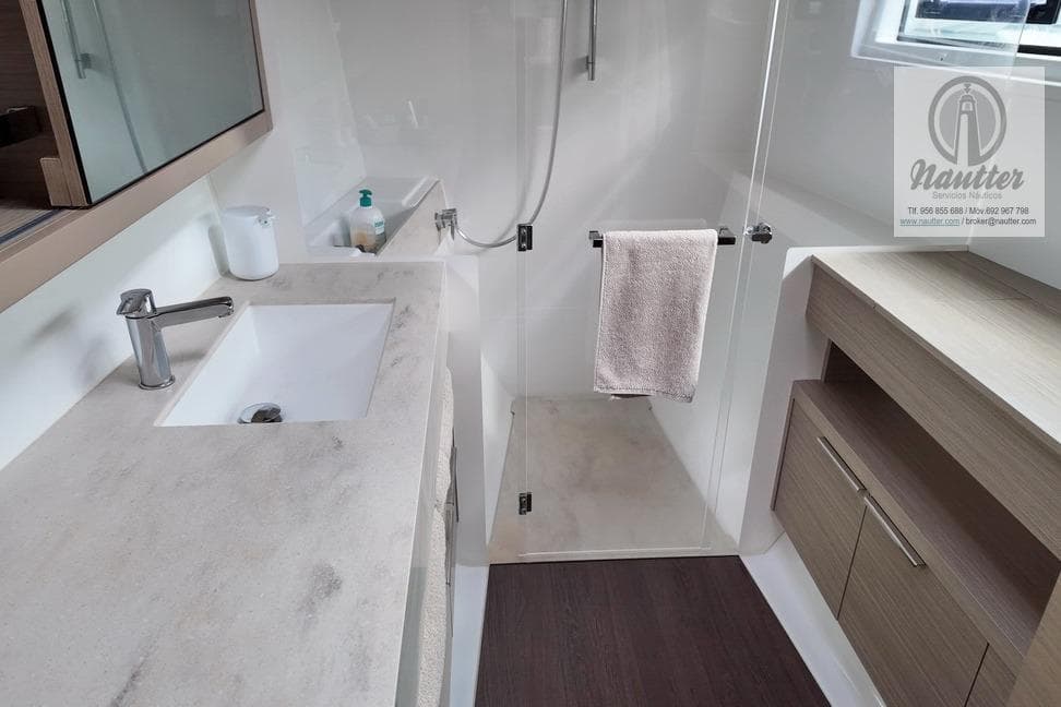 Modern bathroom in 2023 Lagoon 46 yacht with sleek fixtures and glass shower.