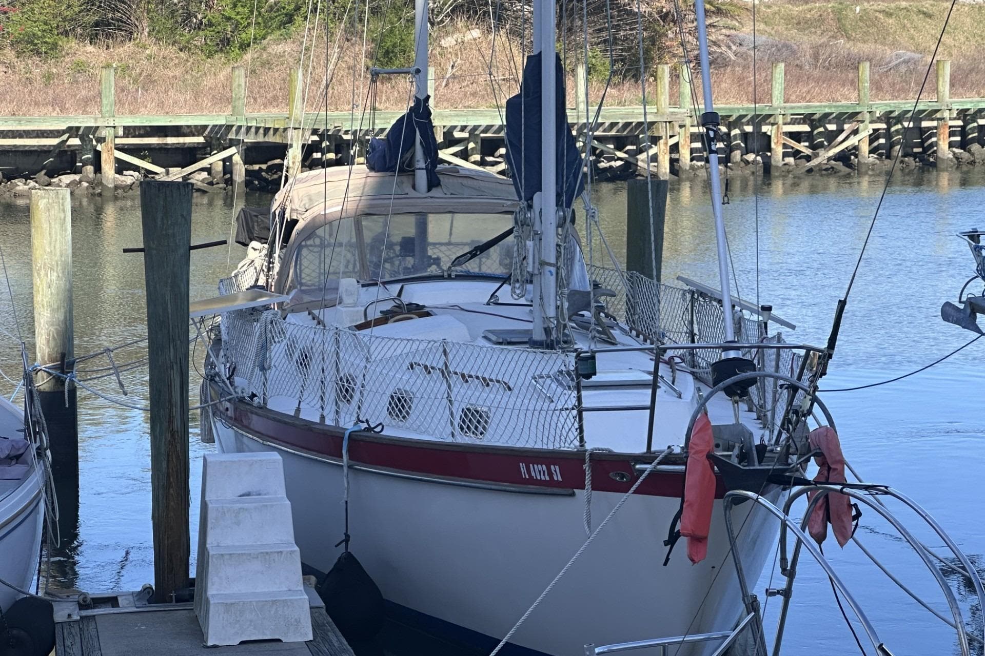 1981 Pearson 424 sailboat docked at a marina, featuring a classic design and safety netting.