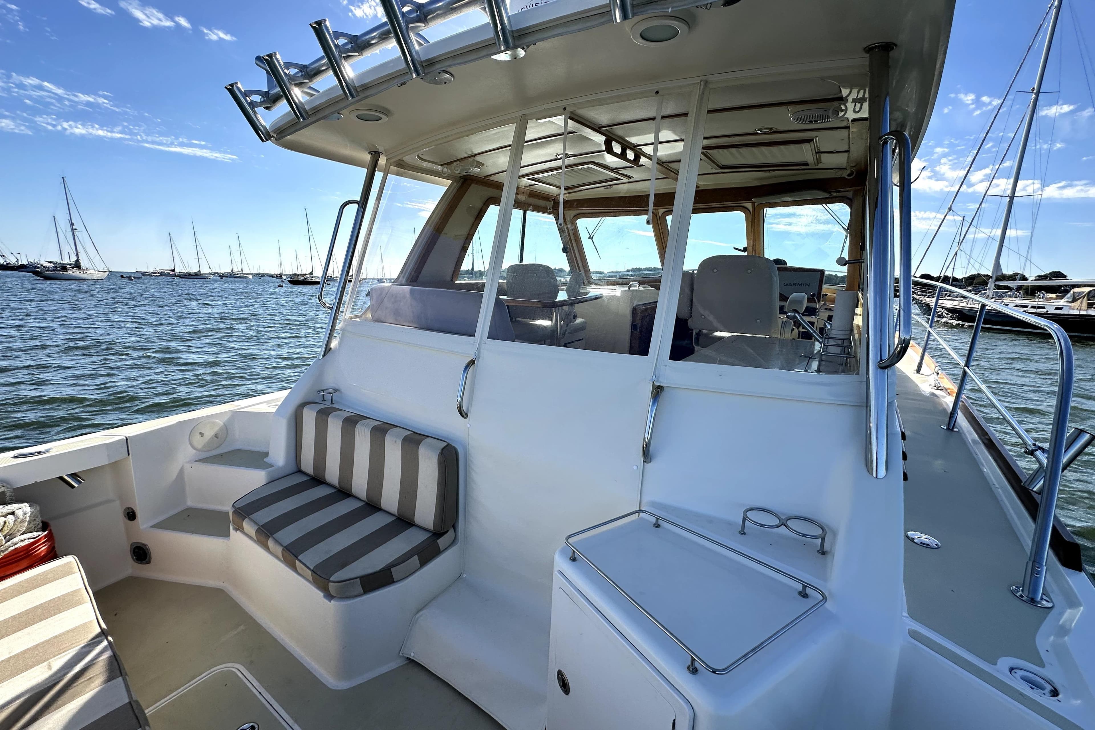 2007 Sabre 34 Express boat with striped seating, docked in a marina under clear skies.