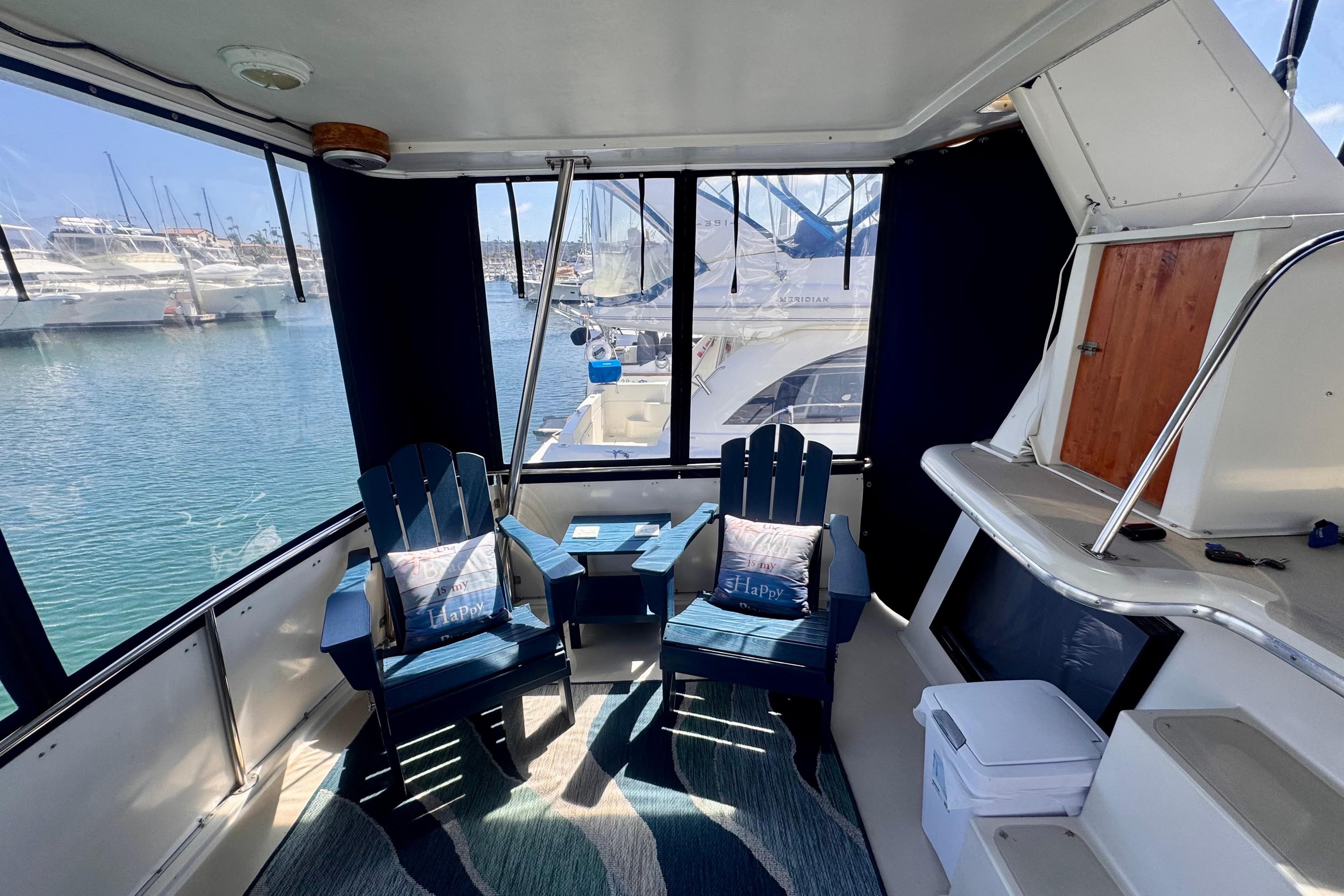 Interior of 1985 Californian 35 Motor Yacht with chairs and marina view.