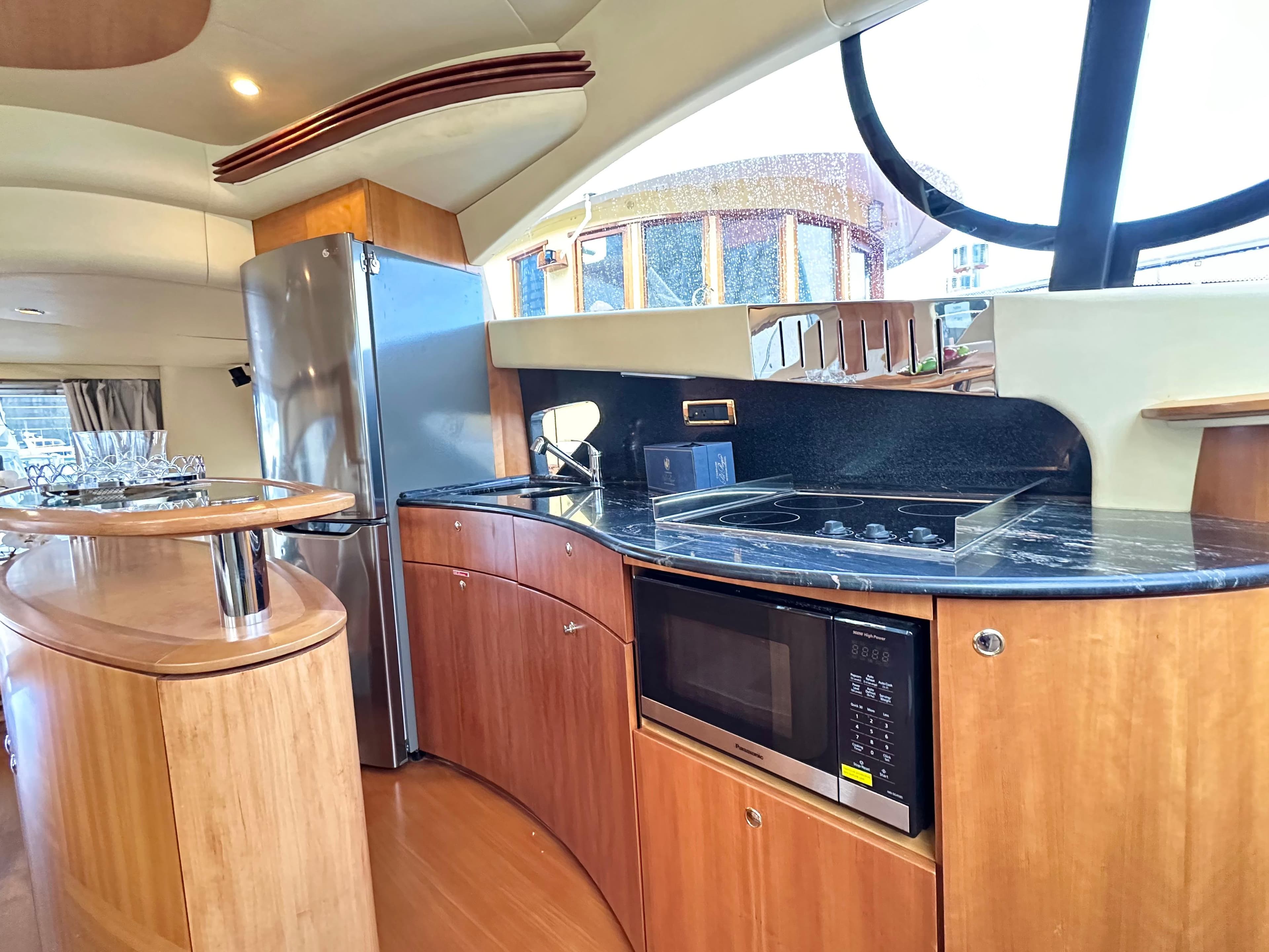 Luxurious kitchen interior of 2011 Azimut 55E yacht with modern appliances and wood finish.