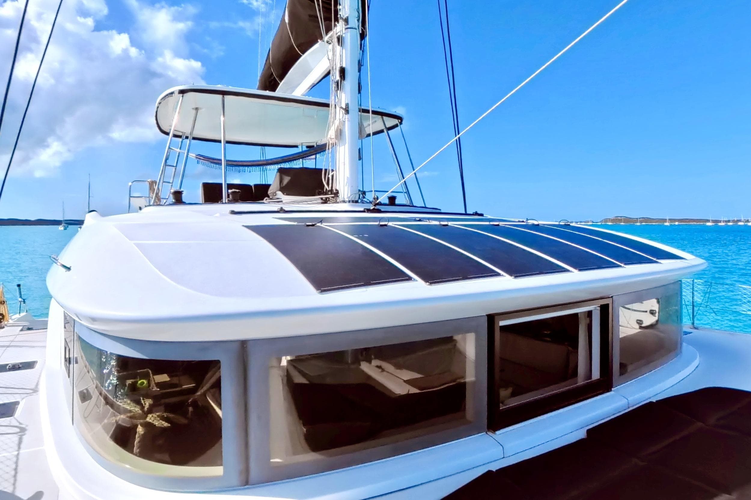2023 Lagoon 50 catamaran with solar panels, sailing on clear blue waters.