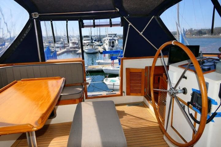 Interior view of 1982 Ta Shing Mason 63 yacht with wooden steering wheel and seating area.