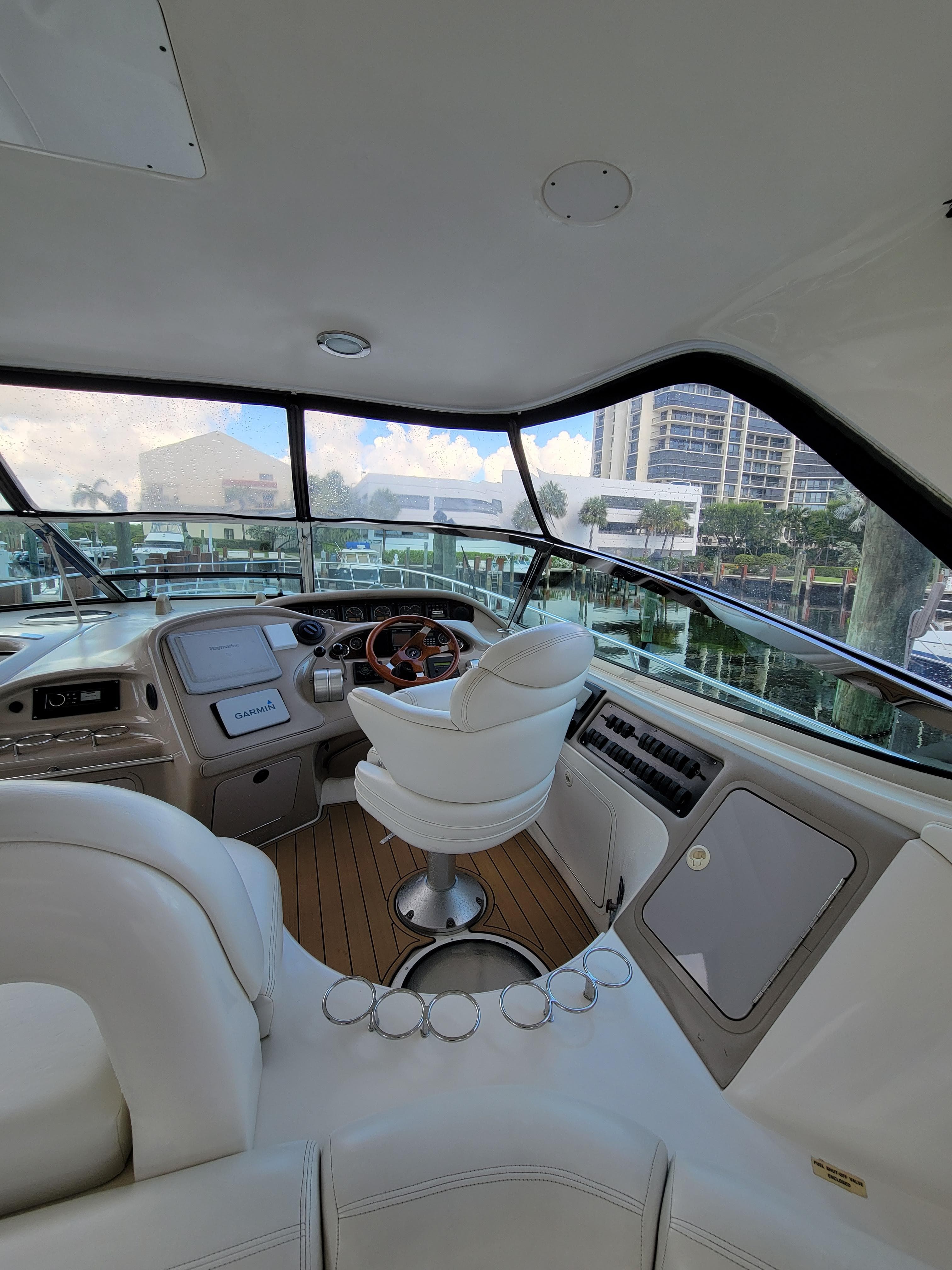 Interior helm of 2000 Sea Ray 540 Sundancer yacht with modern controls and white seating.