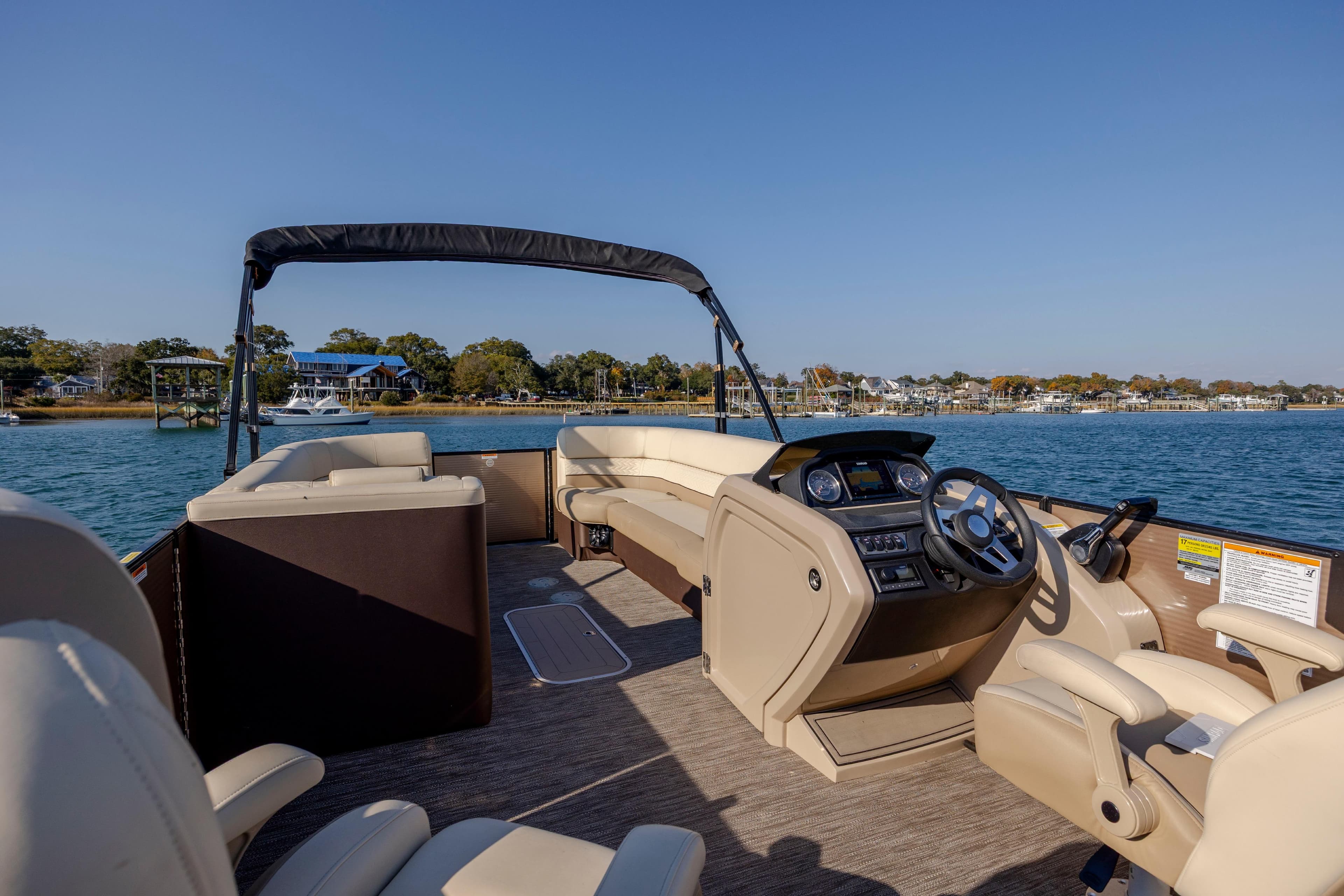 2022 Godfrey Monaco 255 SFL pontoon boat interior with steering console, on a sunny lake.