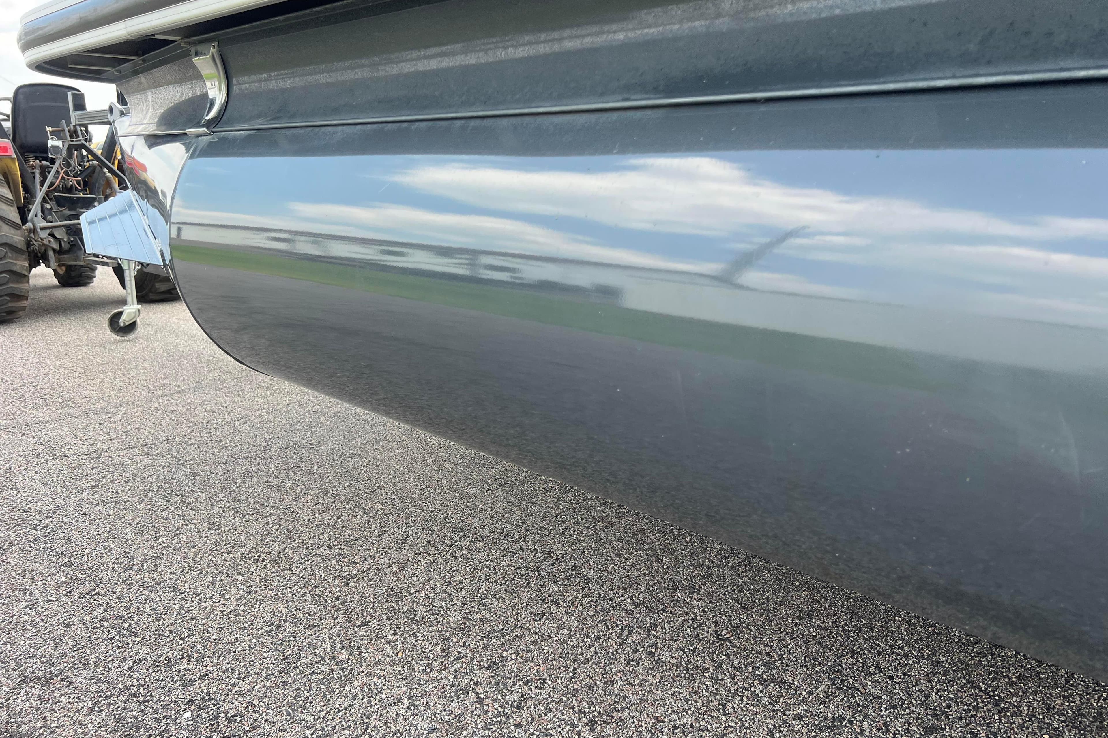 2019 Ranger Reata 200C boat hull reflecting sky and surroundings on pavement.