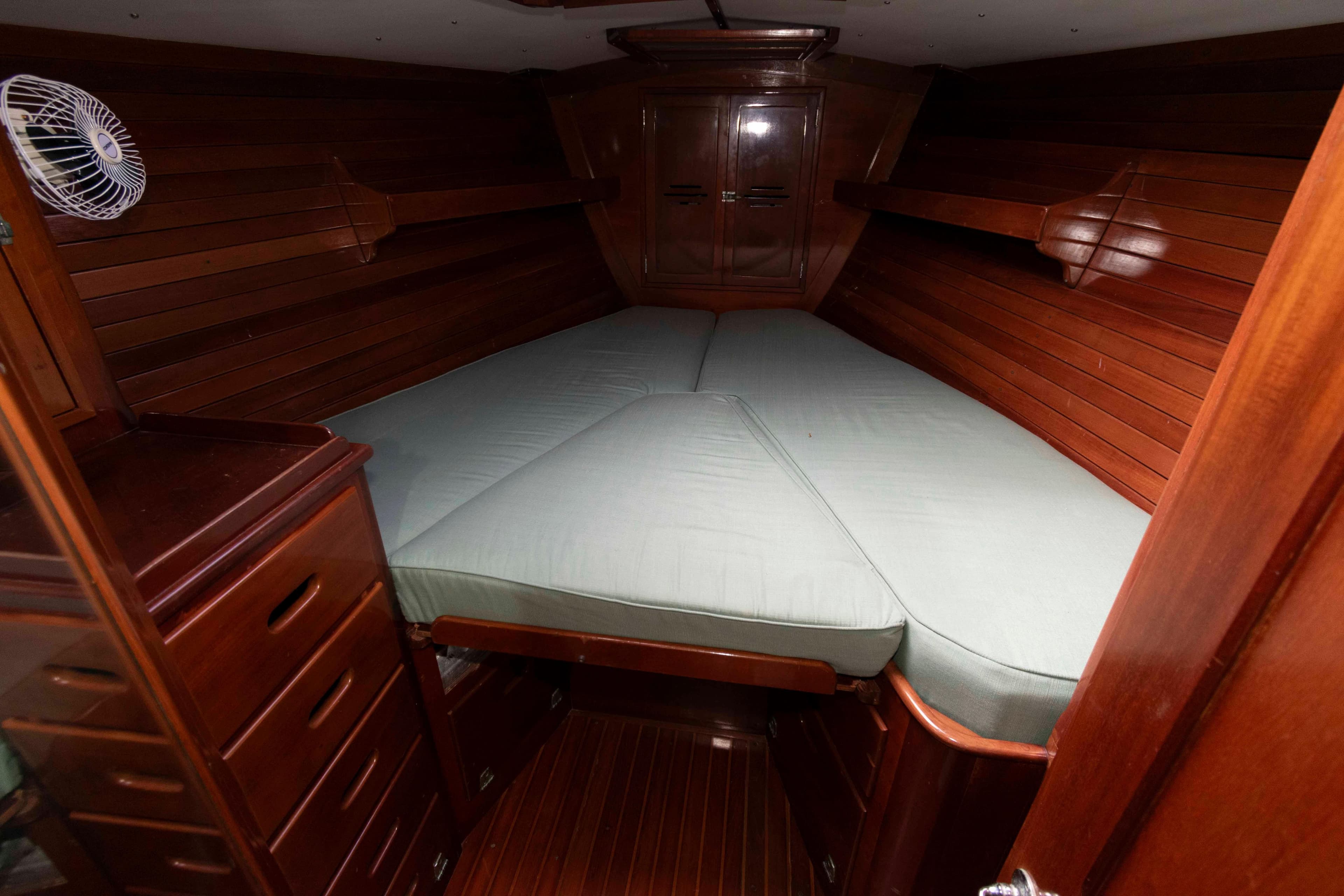 1979 Hinckley 43 Sloop cabin interior with wooden finish and cozy bed.