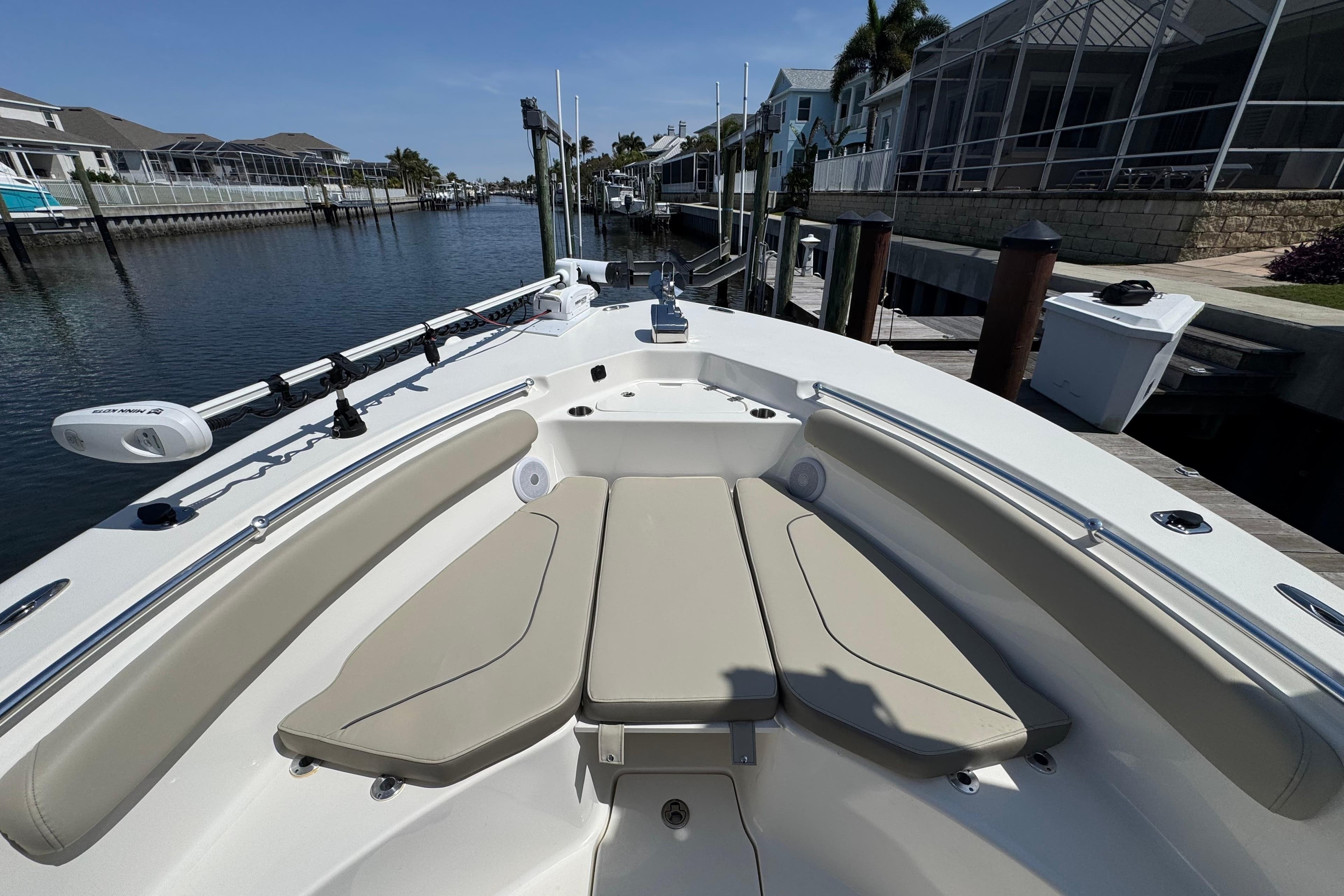 2022 Key West 244 Center Console boat interior with beige seating, docked by waterfront homes.