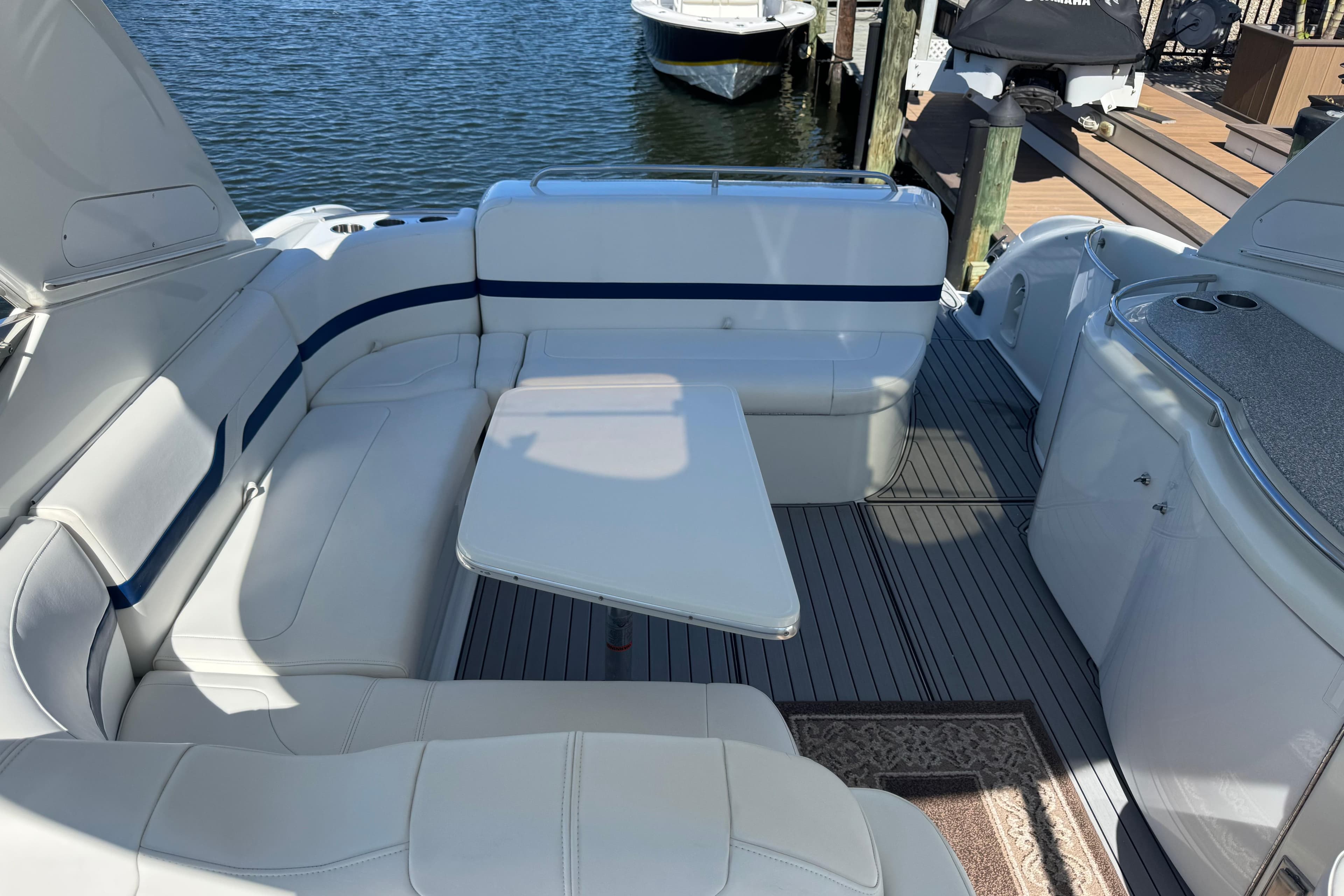2006 Formula 400 Super Sport boat interior with white seating and table, docked by the water.