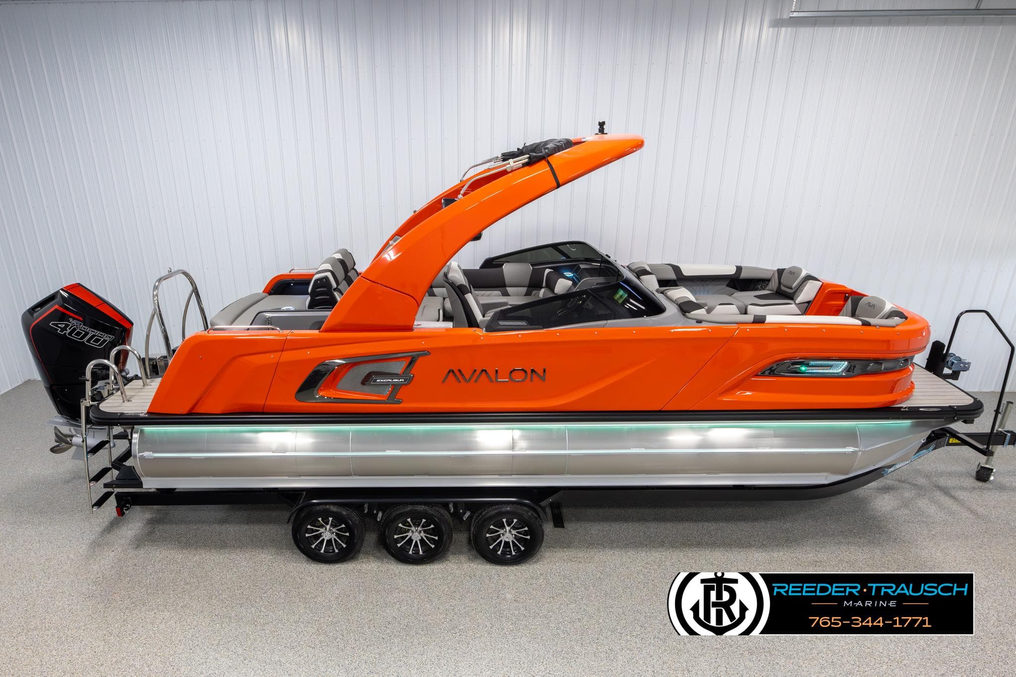 2024 Avalon Excalibur VRB pontoon boat in vibrant orange, displayed indoors.