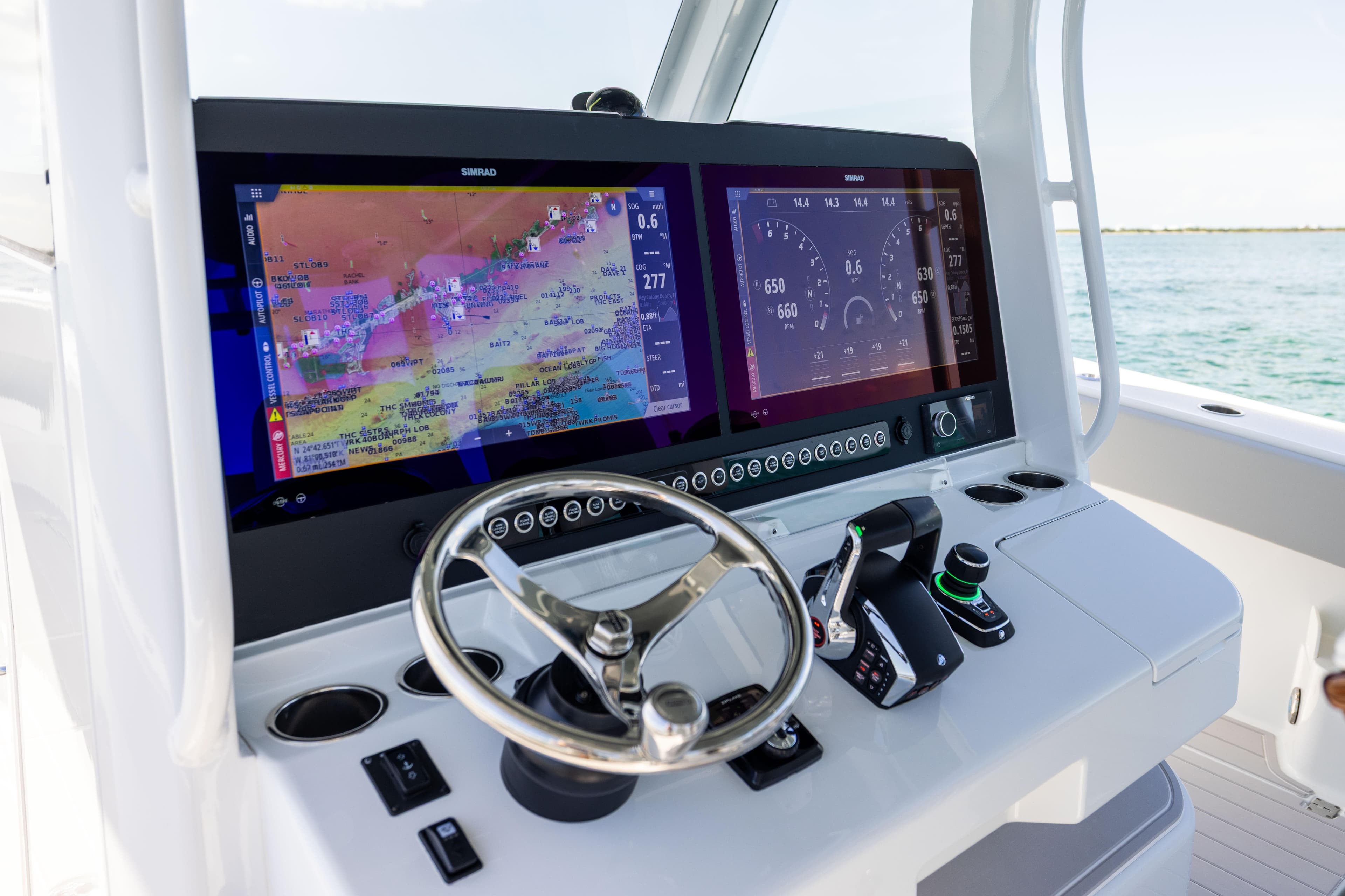 2024 Freeman 43 boat dashboard with dual Simrad displays and steering wheel.