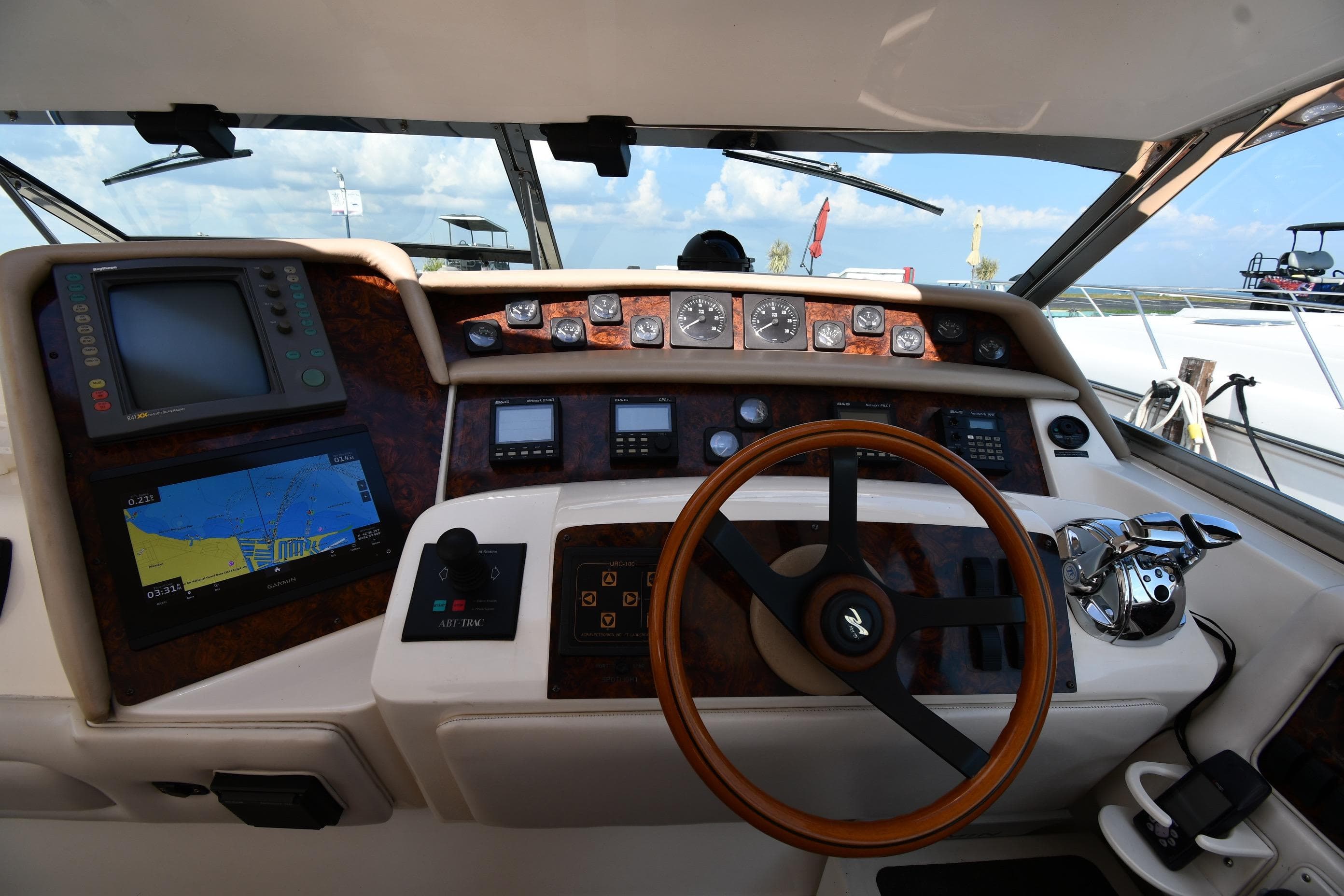 1995 Sea Ray 630 Sundancer helm with navigation equipment and wooden steering wheel.