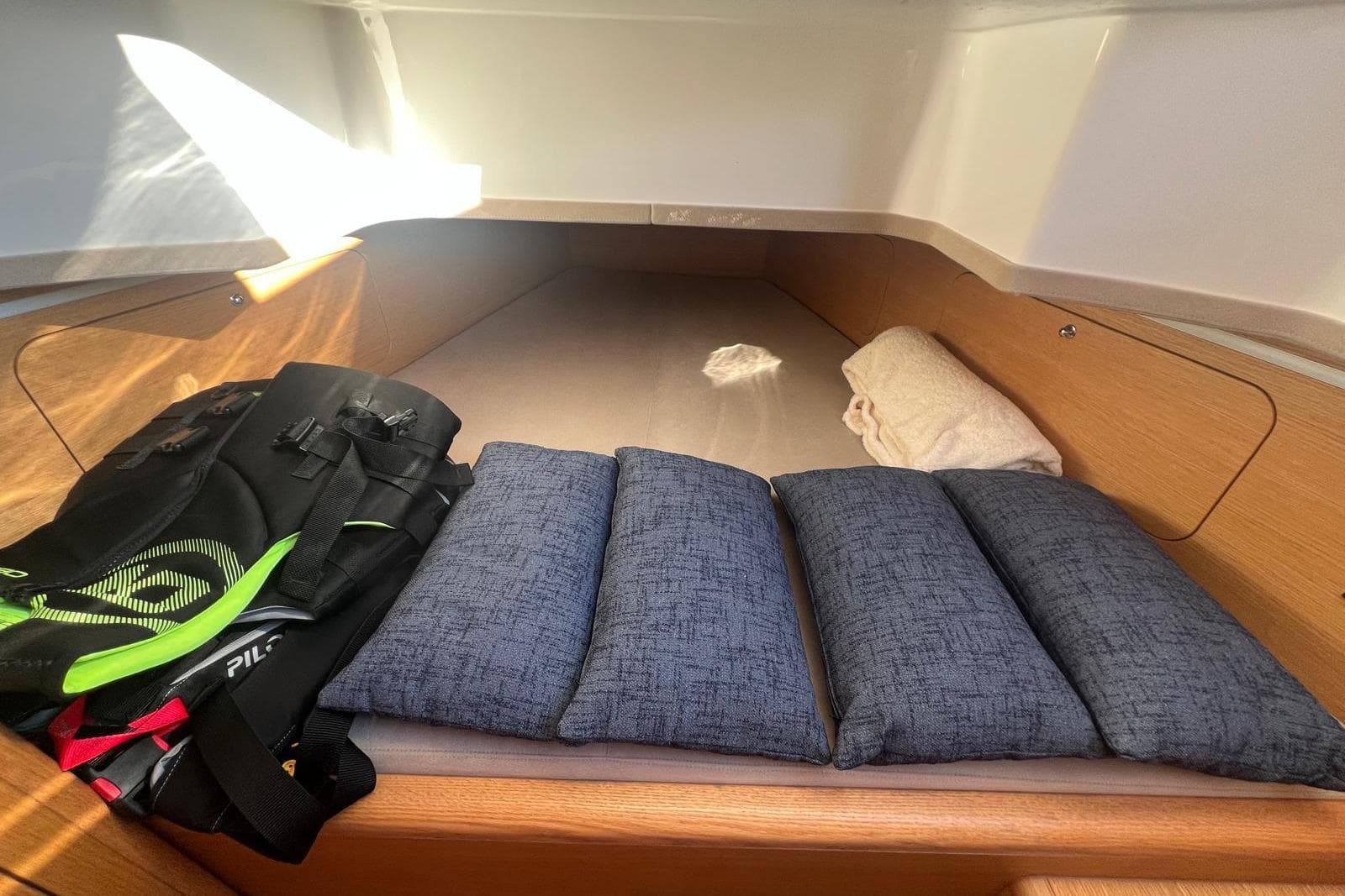 Cozy cabin interior of 2022 Skipper NC 42 with cushions and gear bag.