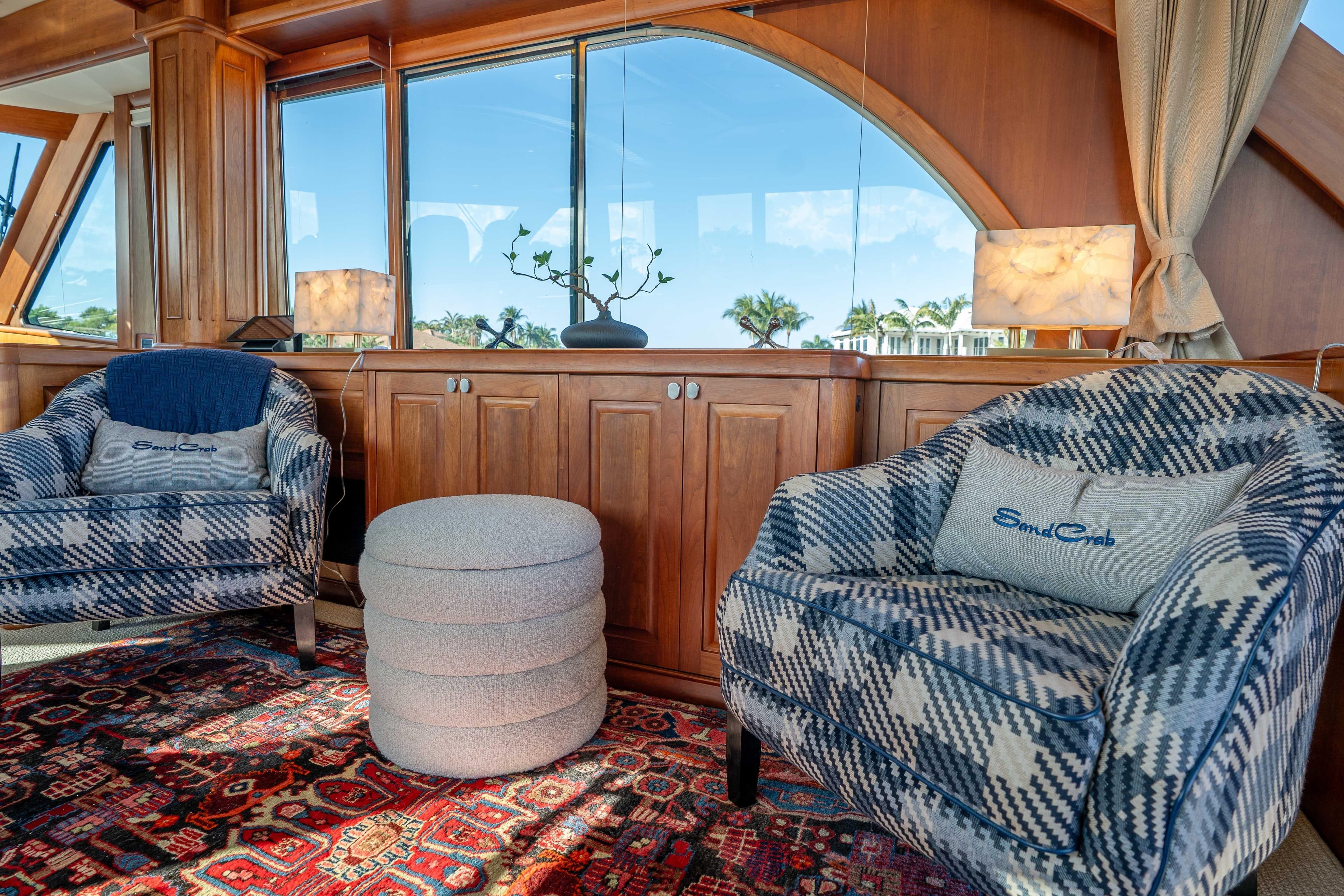 Luxurious interior of 2018 Sabre 66 Dirigo yacht with plaid chairs and elegant decor.
