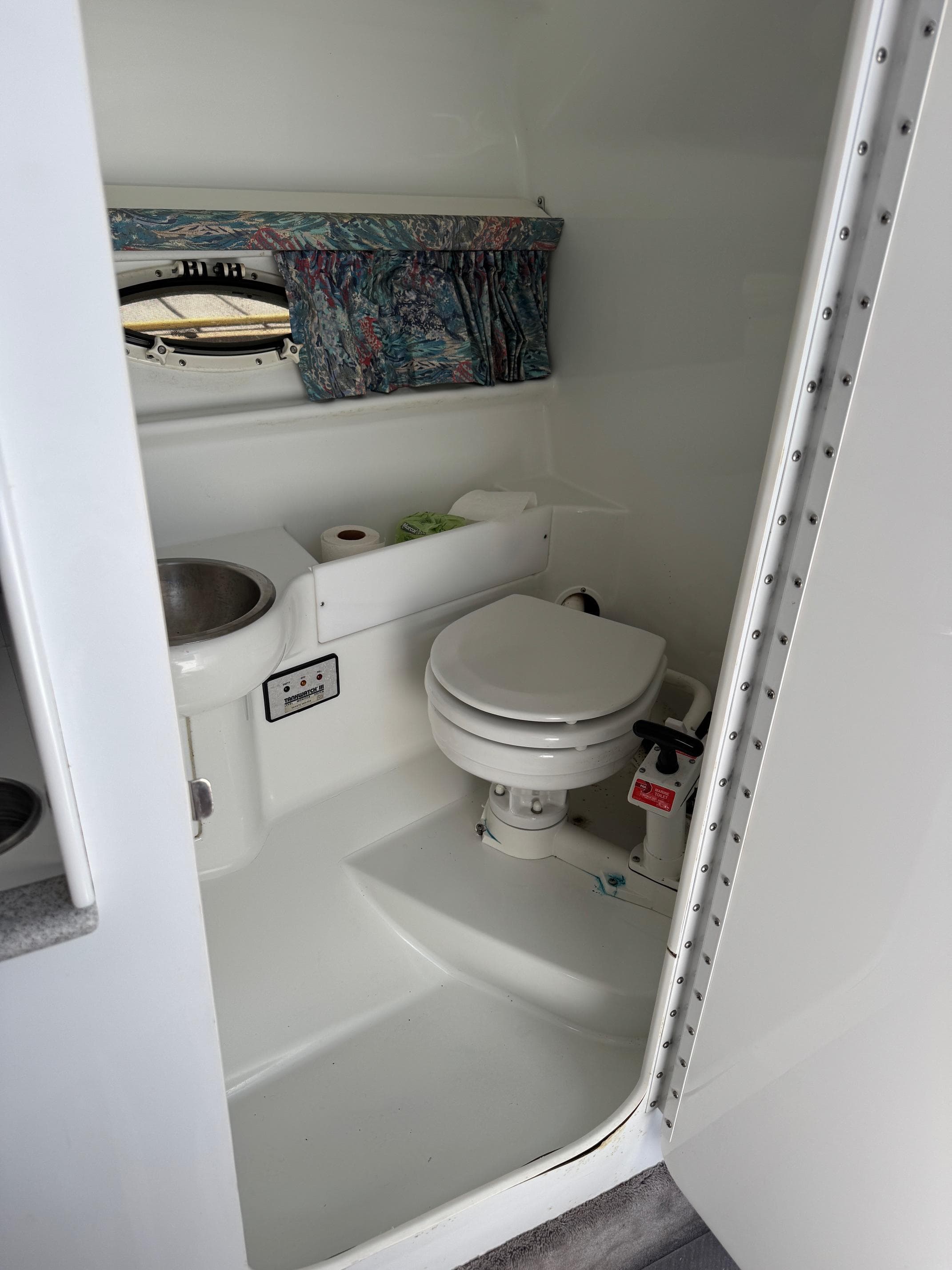 Compact bathroom in a 1996 Formula 280 SS boat, featuring a toilet and sink.