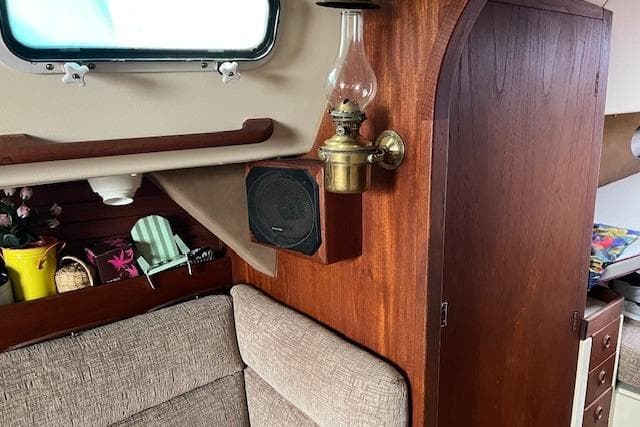 Interior of a 1983 CS 33 sailboat with vintage lamp and cozy seating area.