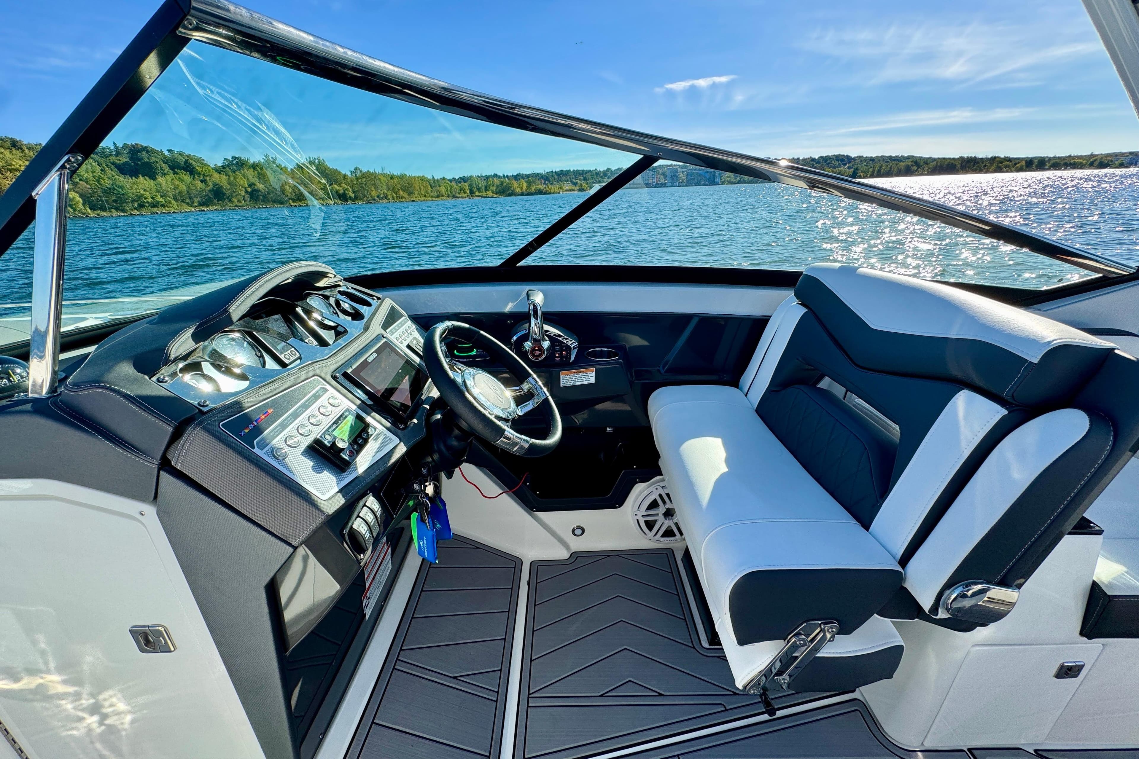 2023 Monterey 305SS Super Sport boat interior with sleek dashboard and comfortable seating on a sunny day.