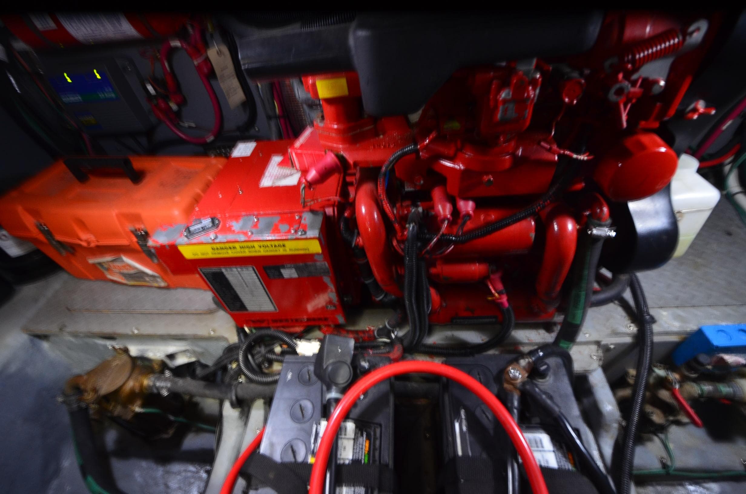 Engine room of 2000 Sea Ray 420 Aft Cabin with red machinery and wiring.