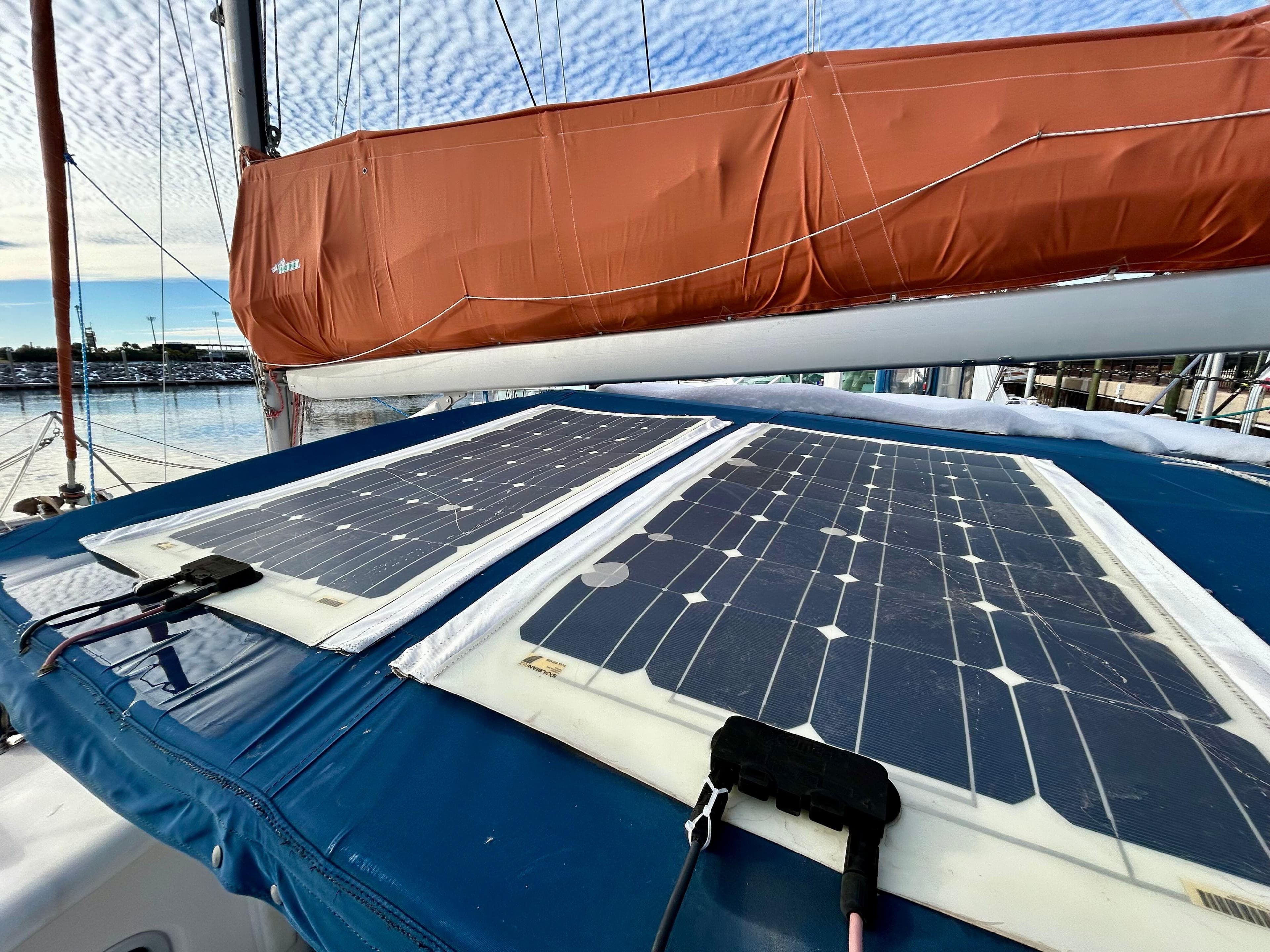 Solar panels on a 2001 Voyage Maxim sailboat with orange sail cover.
