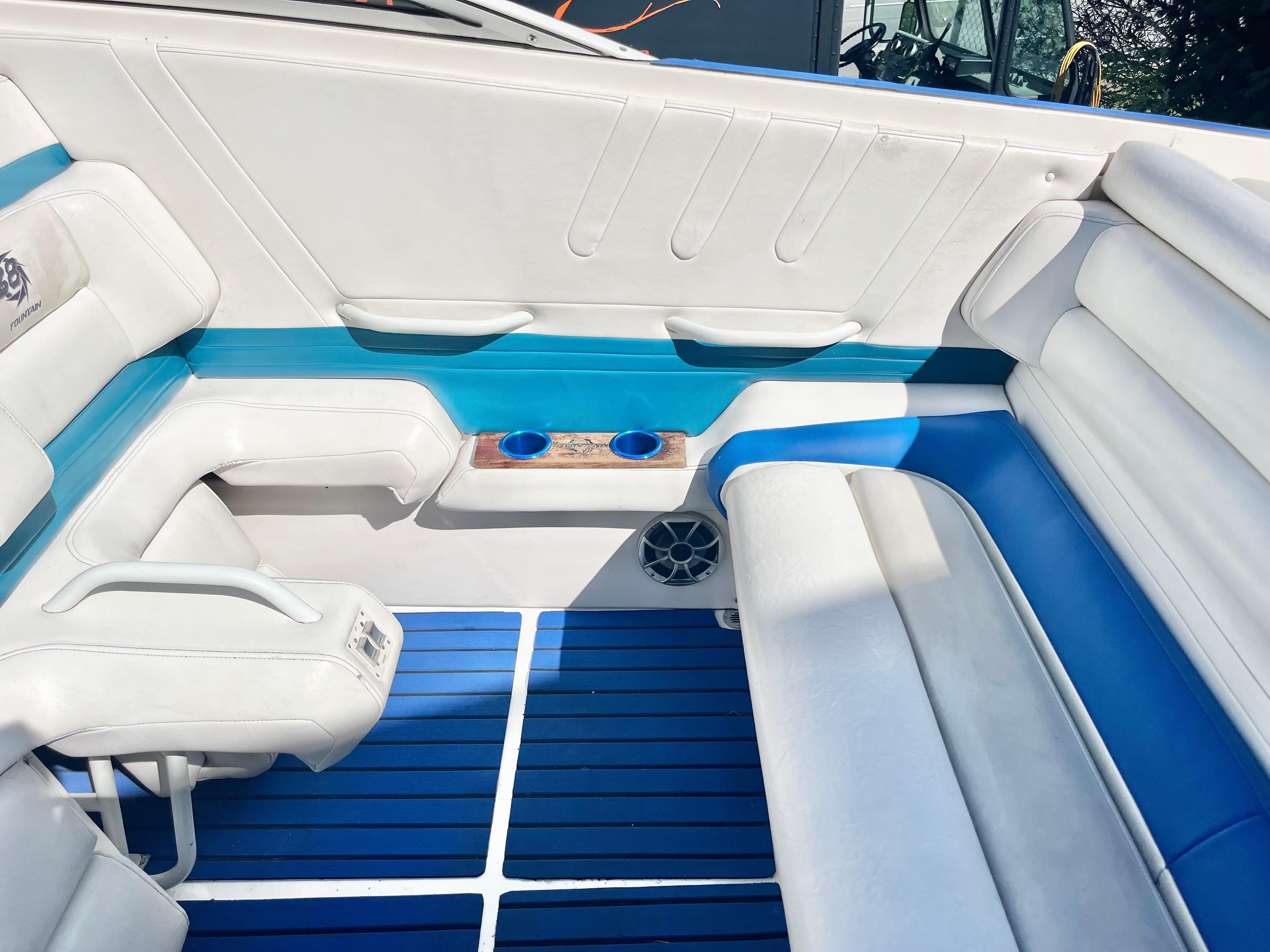 1999 Fountain 38 Sport Cruiser interior with blue and white seating and cup holders.