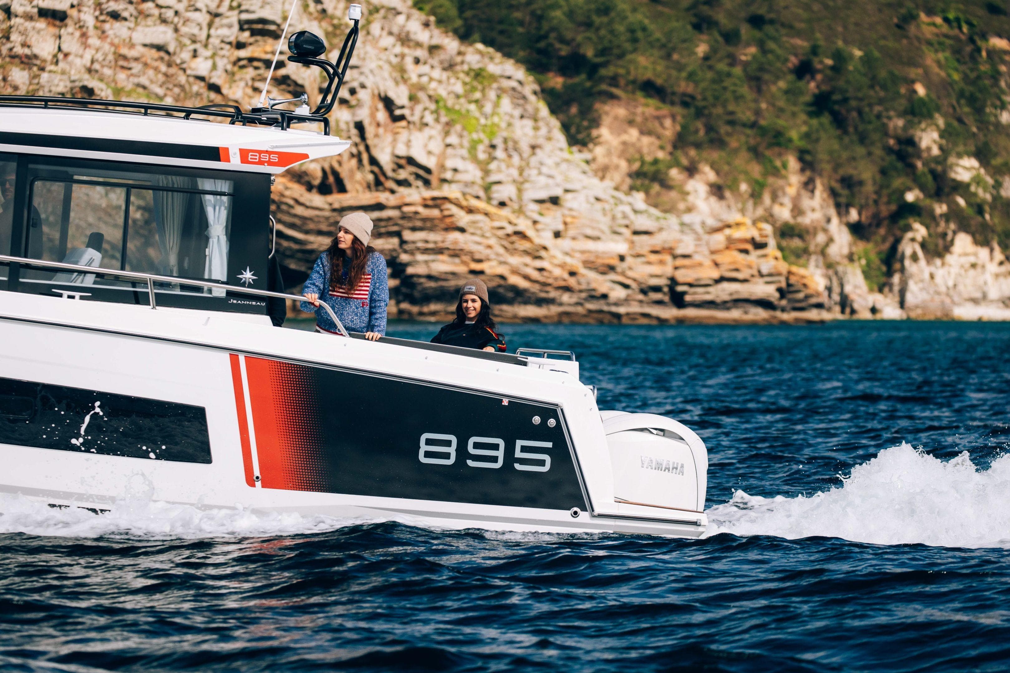 2026 Jeanneau NC 895 Sport Series 2 cruising near rocky coastline.