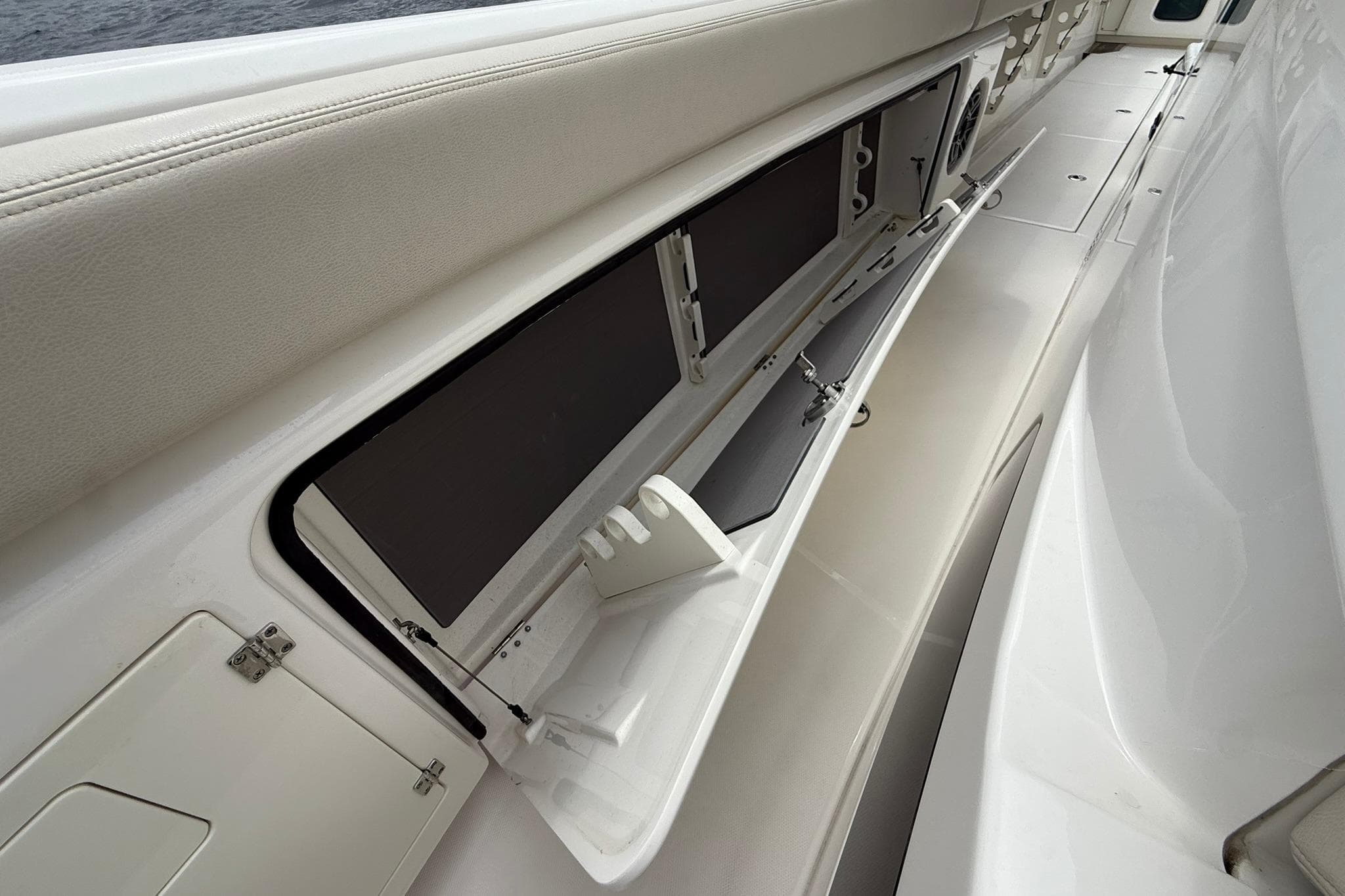 2022 Solace 41CS boat interior storage compartment with open hatch and rod holders.