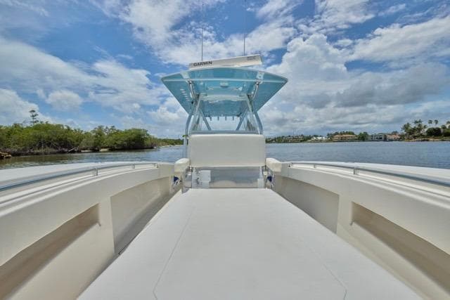 Invincible 36 boat, 2015 model, on calm water under a partly cloudy sky.