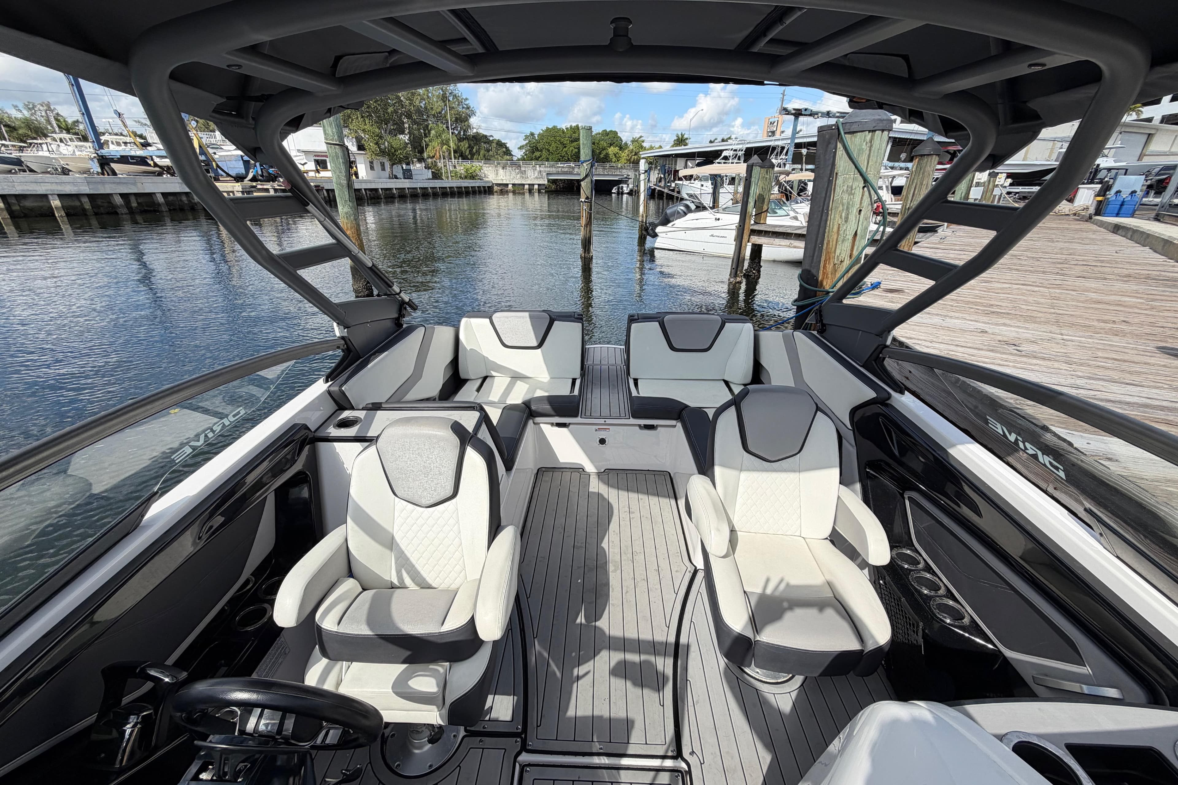 2022 Yamaha Boats 252SD interior with sleek seating and modern design at a marina.