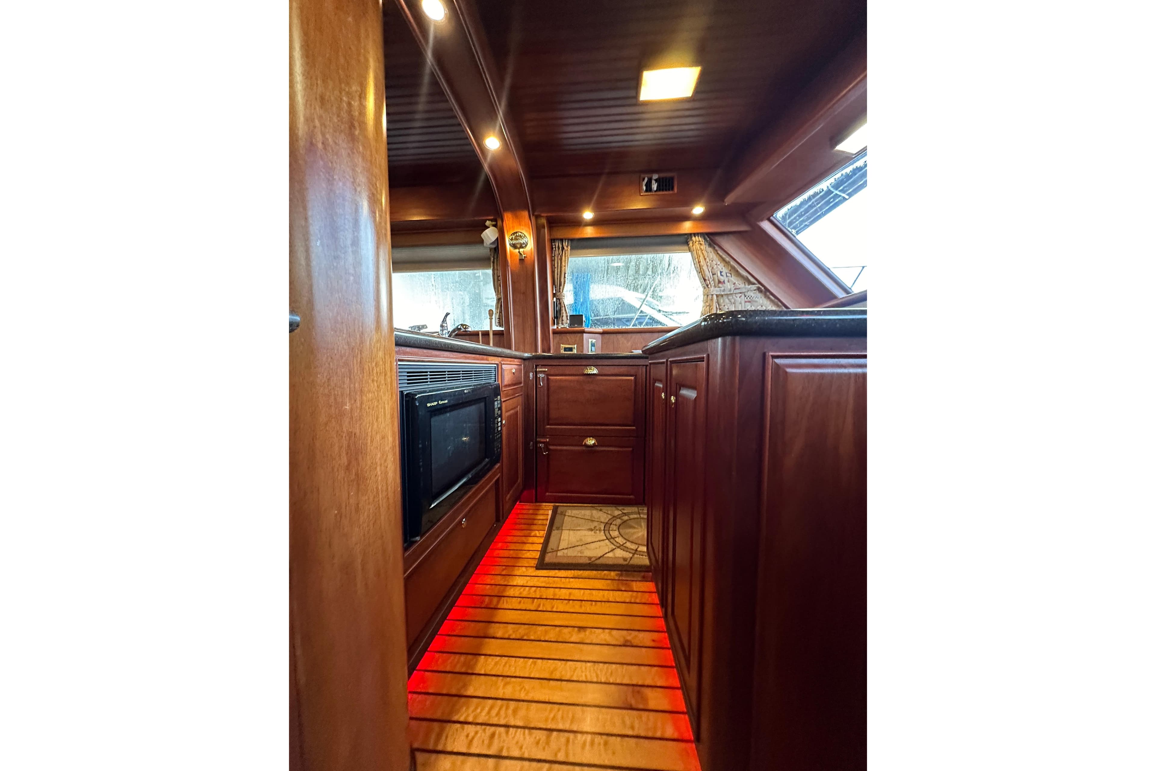Luxurious wooden interior of a 1980 Bertram 58 Convertible yacht kitchen.