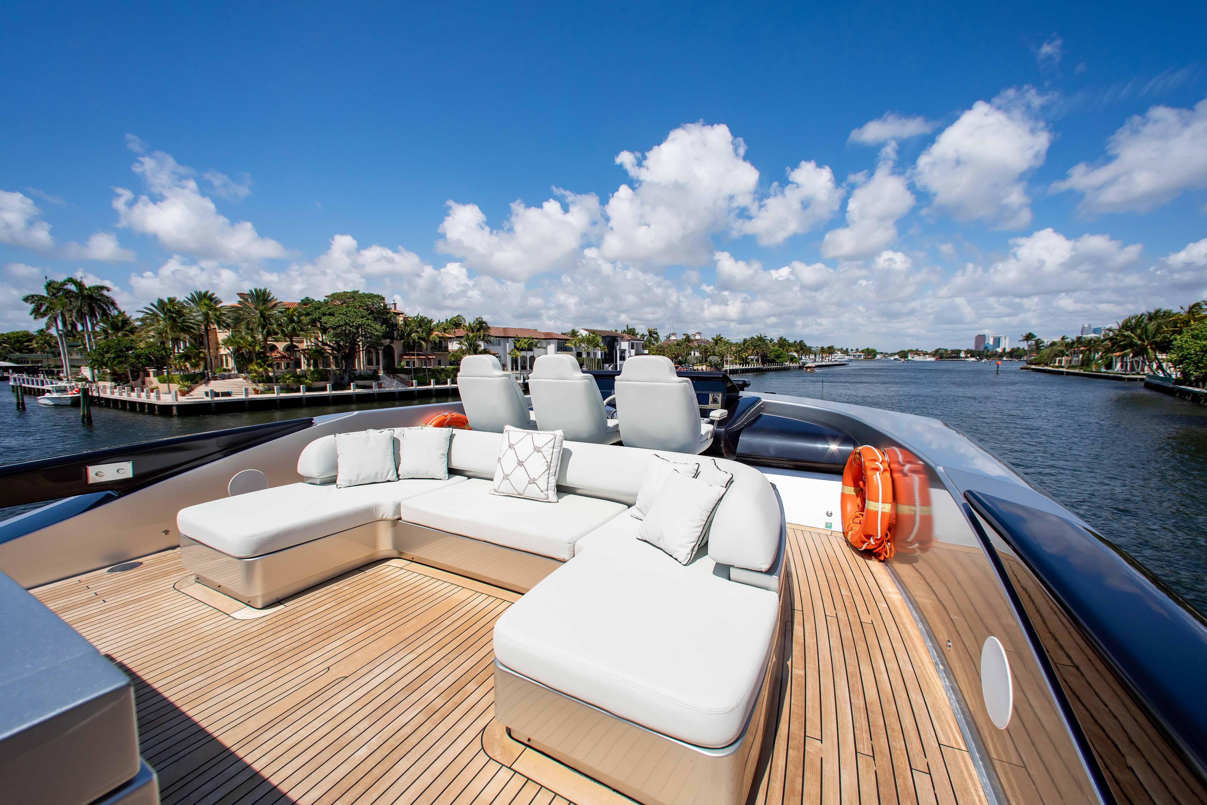 Luxurious 2014 Riva Mythos Motoryacht deck with plush seating, cruising on a scenic waterway.