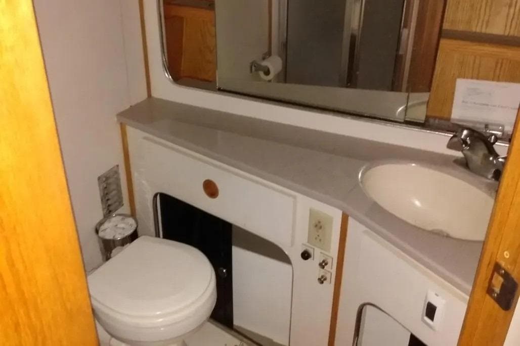Bathroom interior of 1989 Chris-Craft 381 Catalina yacht, featuring sink and toilet.
