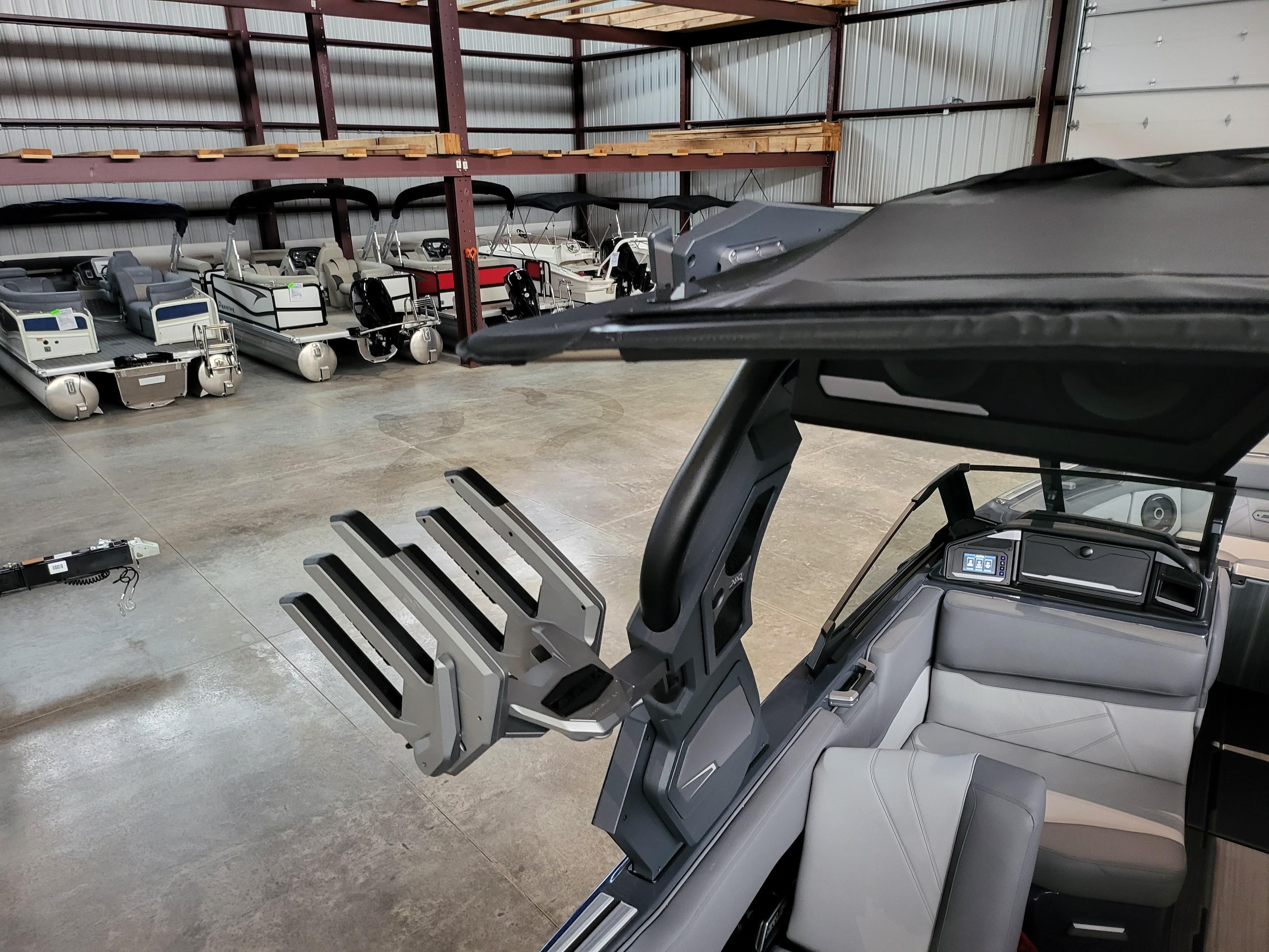 2024 Supra SL boat interior with wakeboard rack in a storage facility.