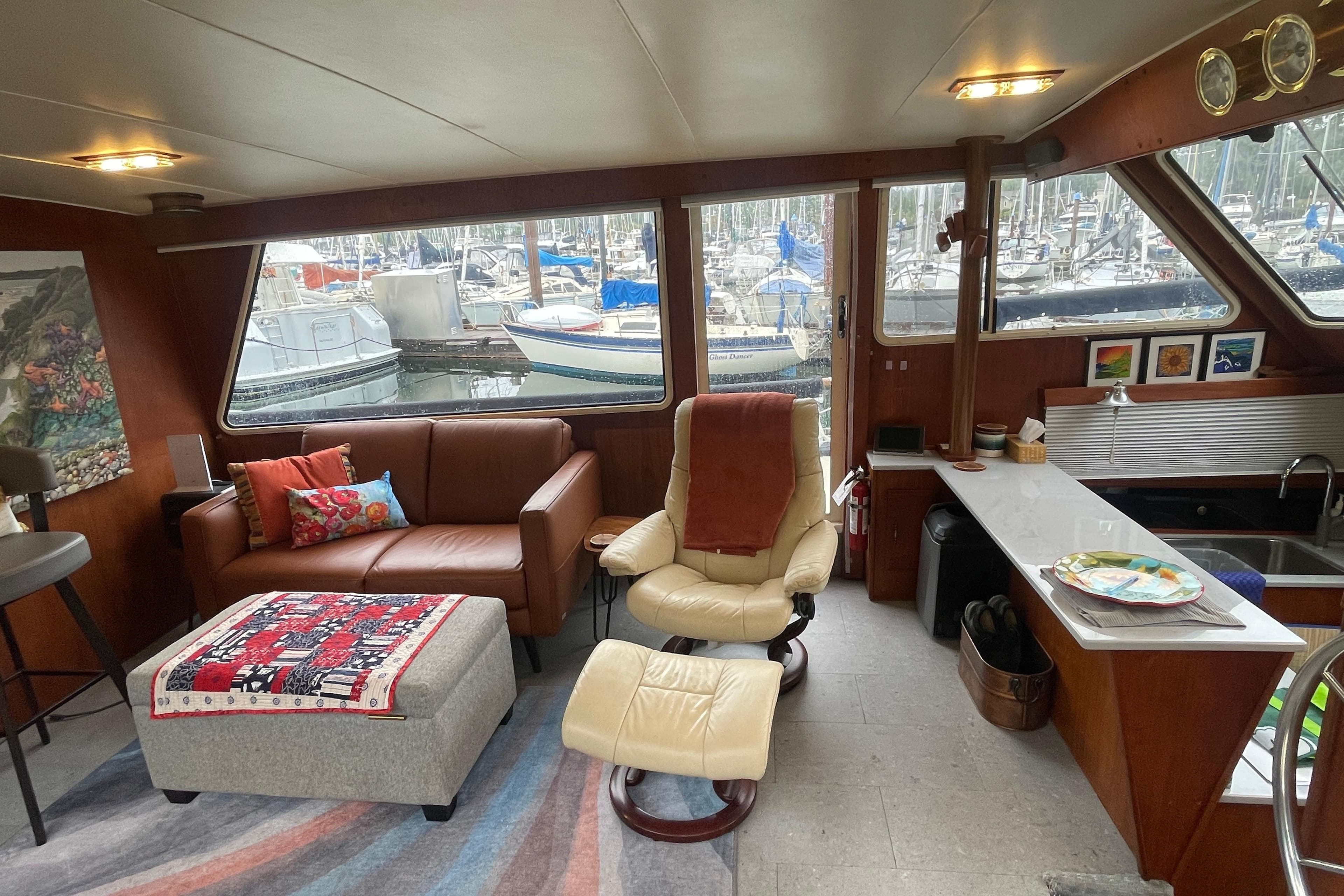 Interior of 1981 Tollycraft 48 Cockpit Motor Yacht with cozy seating and marina view.