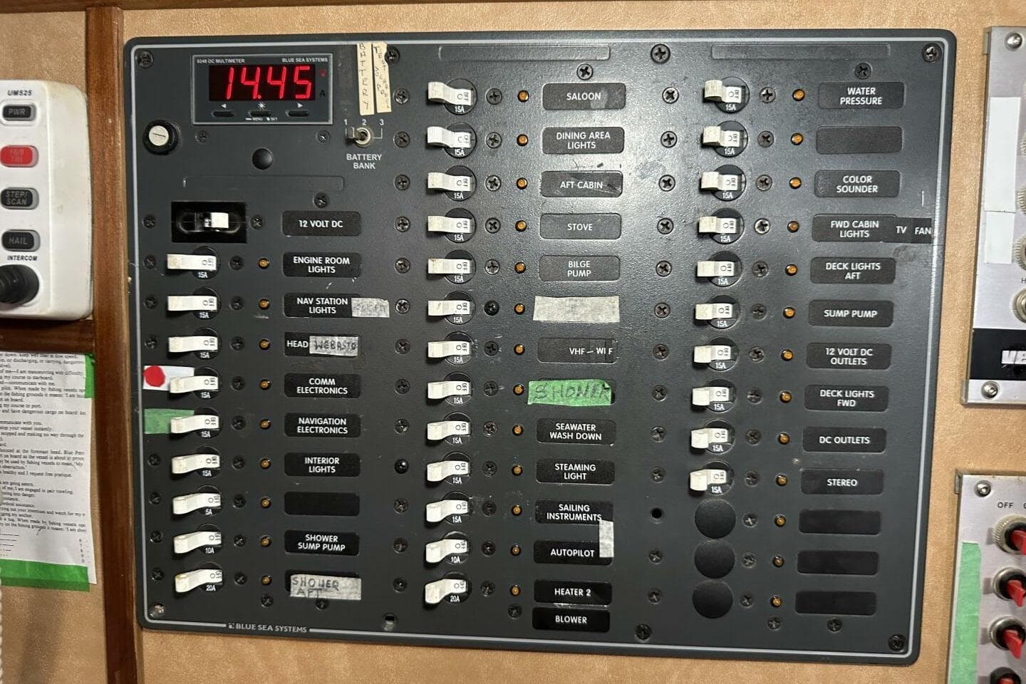 Electrical control panel of a 1979 Hughes 3910 boat with labeled switches and digital display.