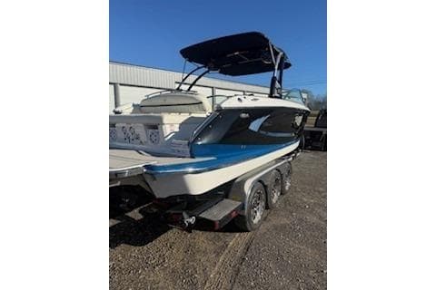 2018 Cobalt A28 boat on trailer, parked outdoors under clear blue sky.