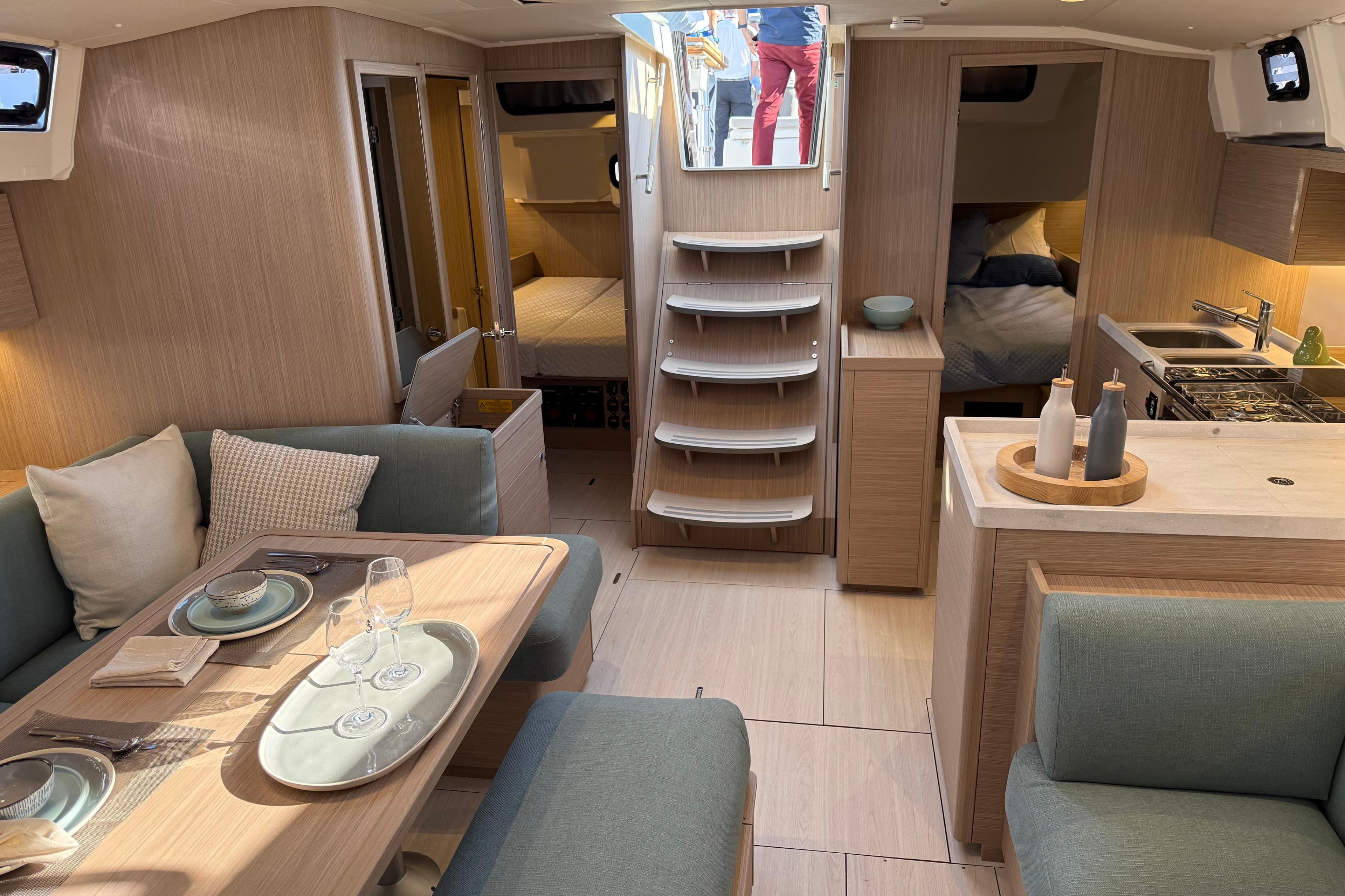 Luxurious interior of 2026 Beneteau Oceanis 47 yacht with modern dining and kitchen area.
