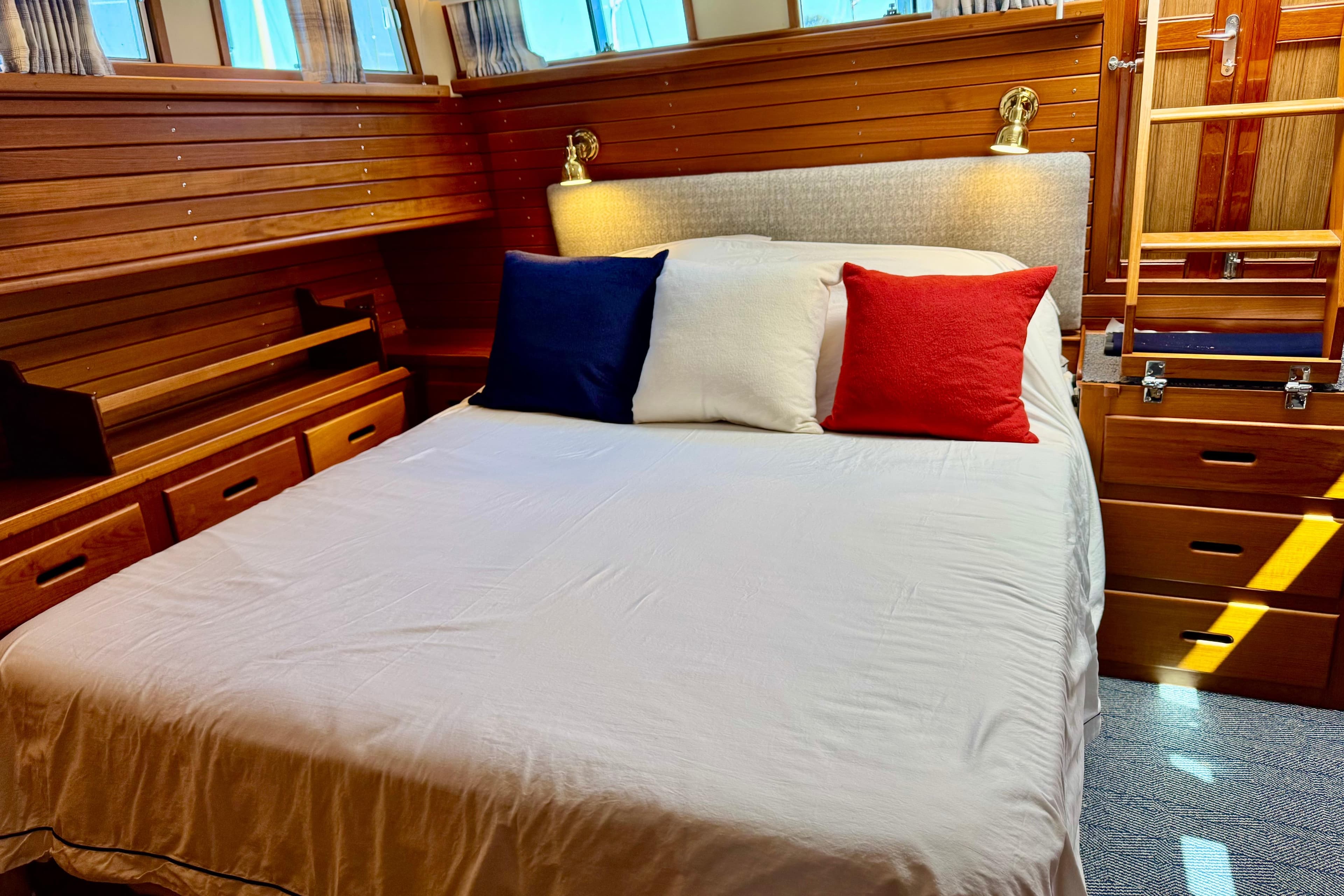 Cozy cabin bedroom in 1996 Grand Banks 46 Heritage CL yacht with colorful pillows.