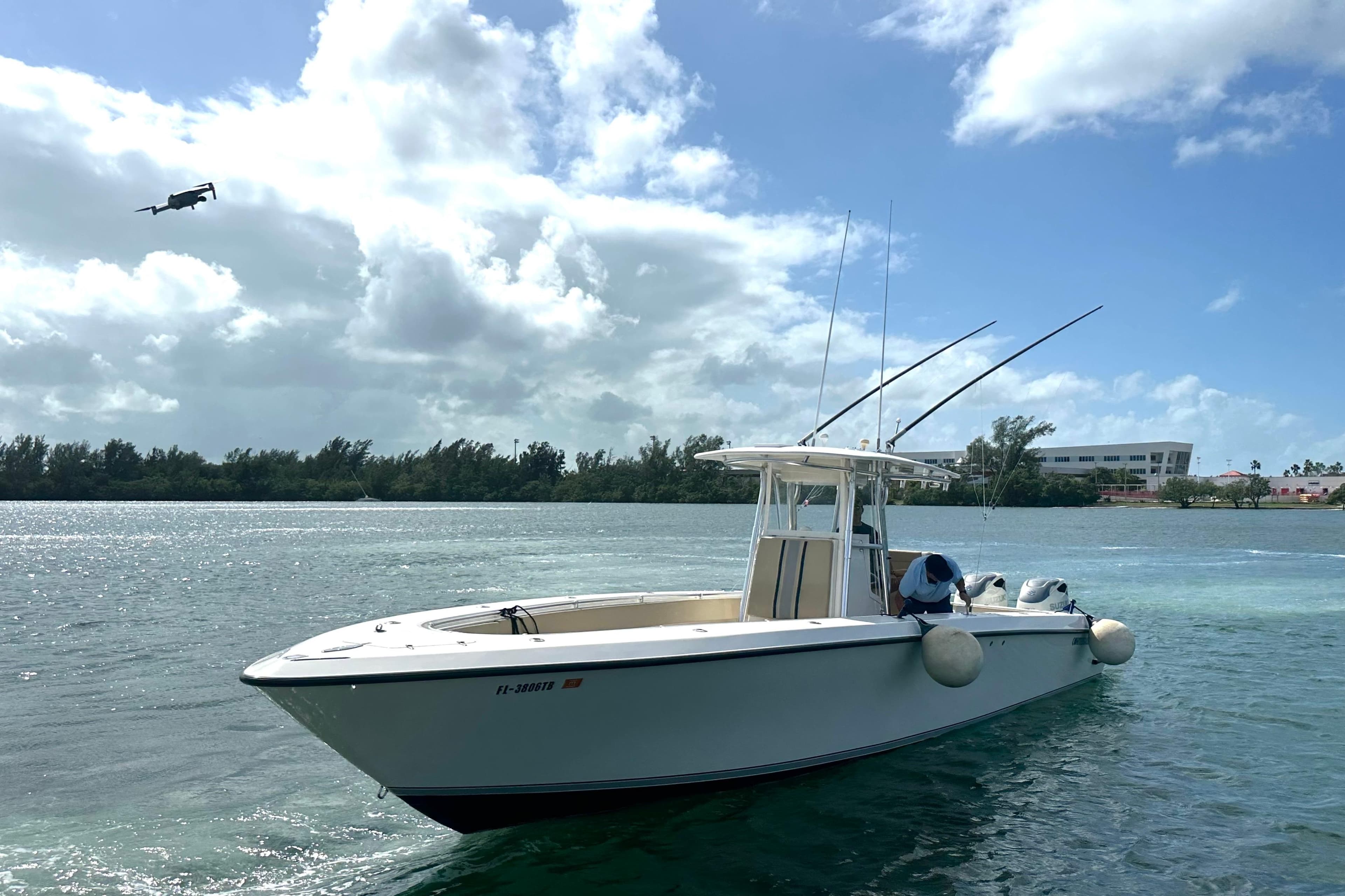 2008 Contender 36 Open boat on water with fishing rods, under a partly cloudy sky.